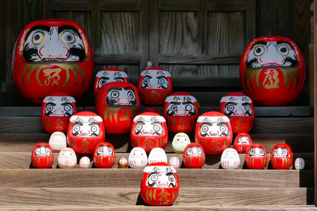 Plusieurs Daruma de tailles variées dans un temple japonais