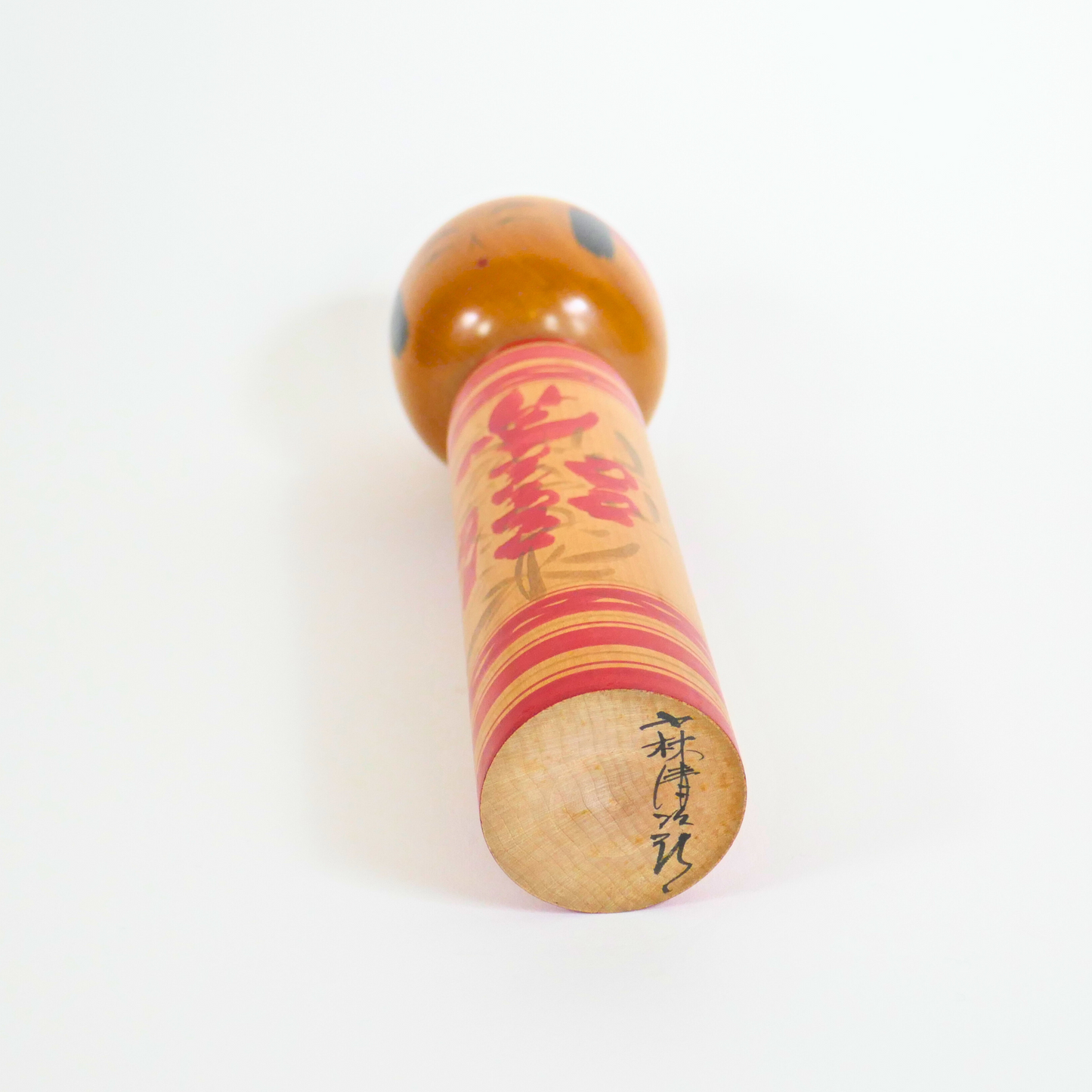 signature de l'artiste kobayashi seijiro sur une kokeshi en bois