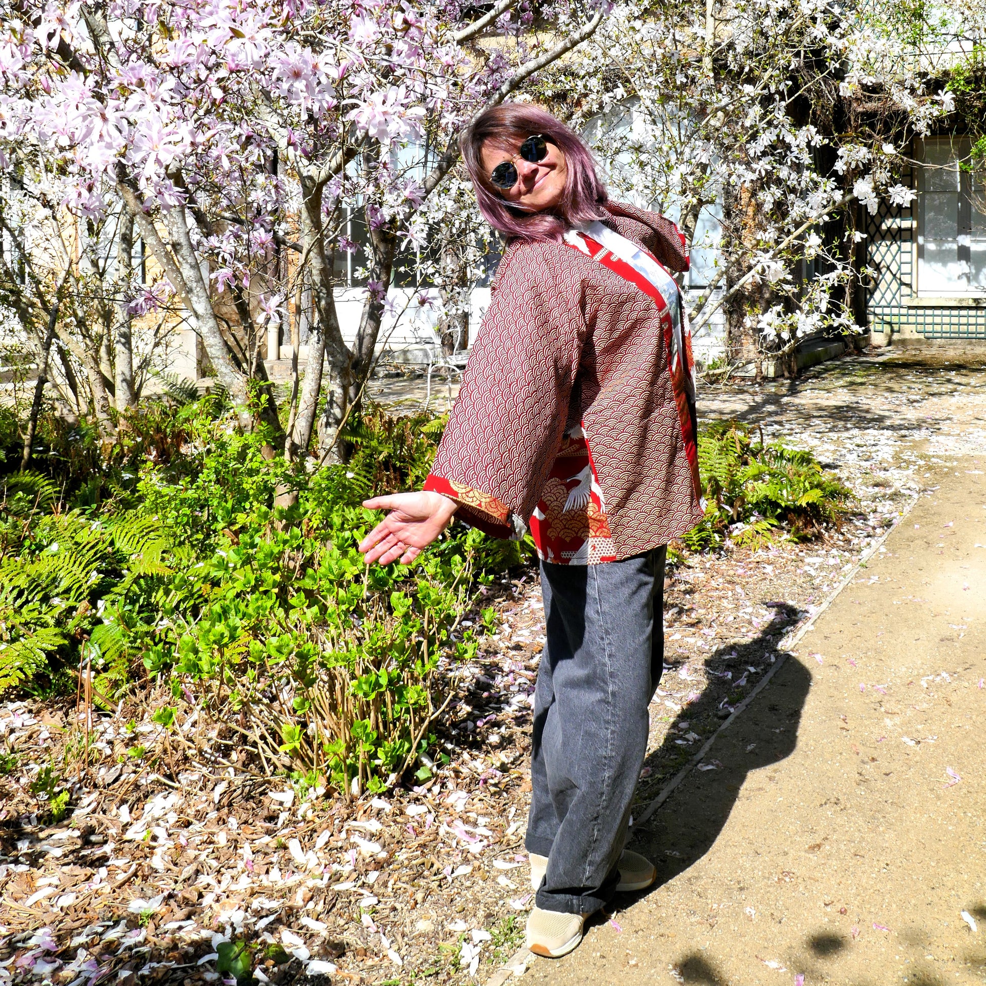 Mikan est heureuse de porter le haori Akane Tsuru dans un jardin de magnolias en fleurs,