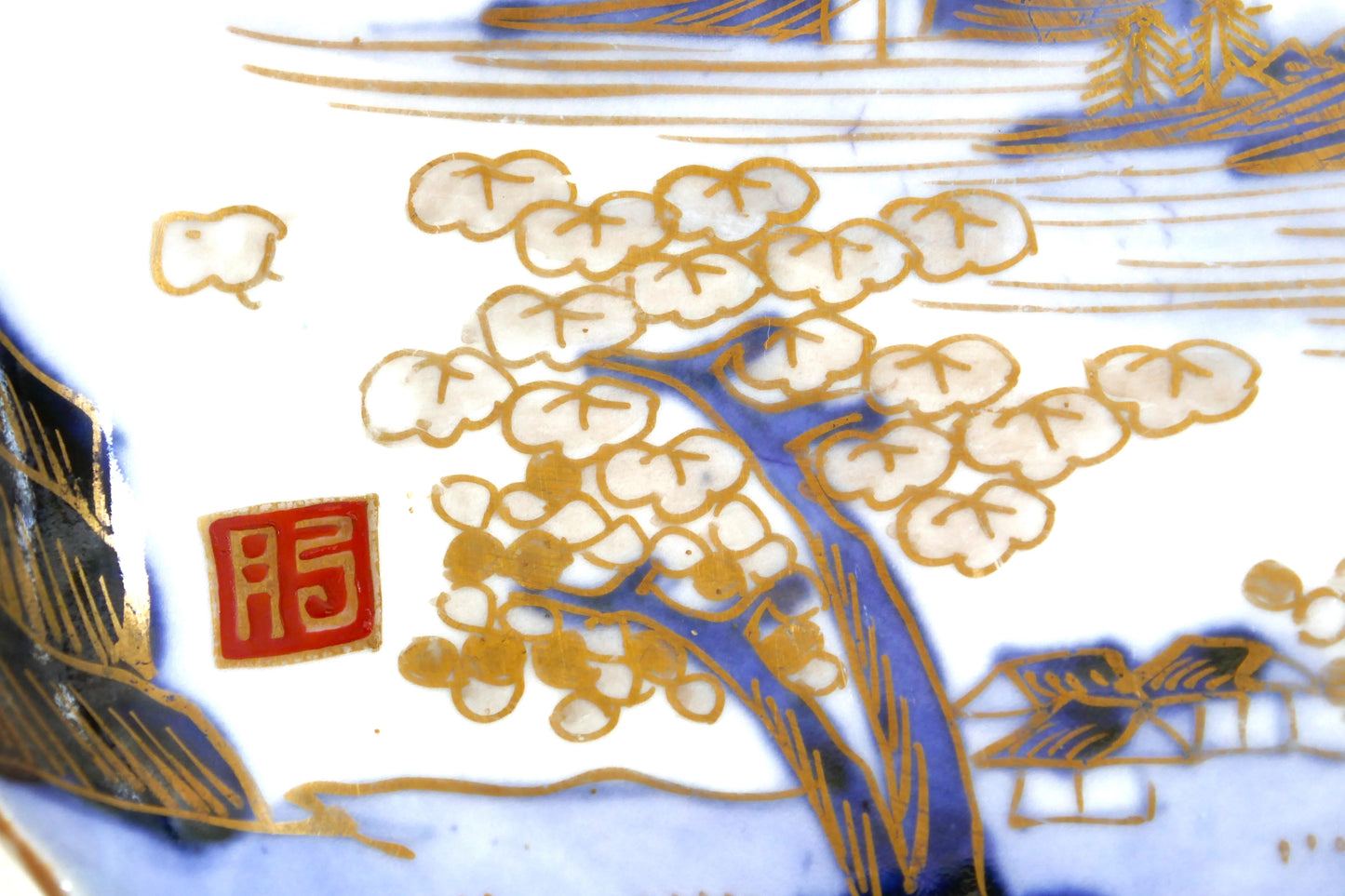Gros plan sur le cerisier en fleurs et le sceau rouge « Hi » (Hizen) sur assiette Arita Meiji