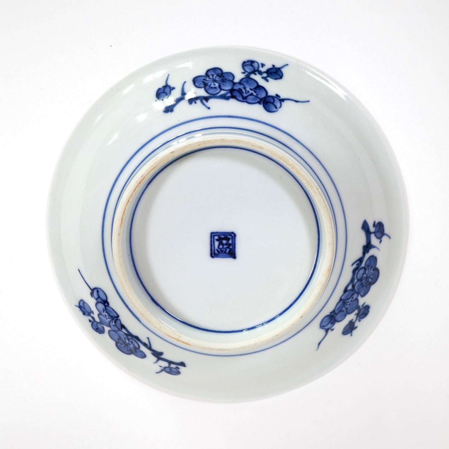 Assiette Imari Arita vue de face, décor polychrome Sho Chiku Bai (pin, bambou, prunier), émaux rouge, jaune, vert et bleu. Kanji 藍 (Ai), marque régionale de Hizen par Iwao Engineering