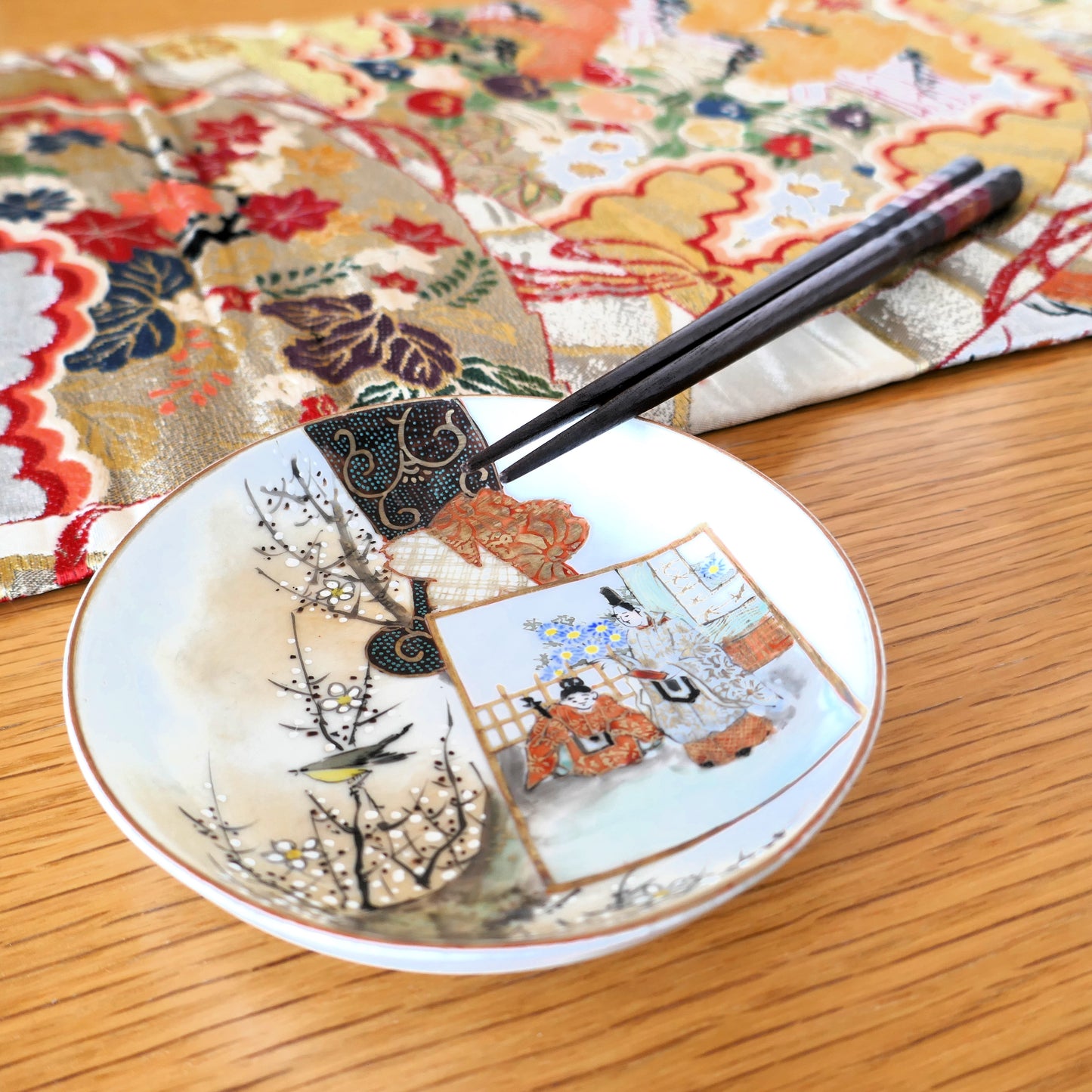 Assiette Kutani mise en scène avec baguettes japonaises et tissu traditionnel à motifs