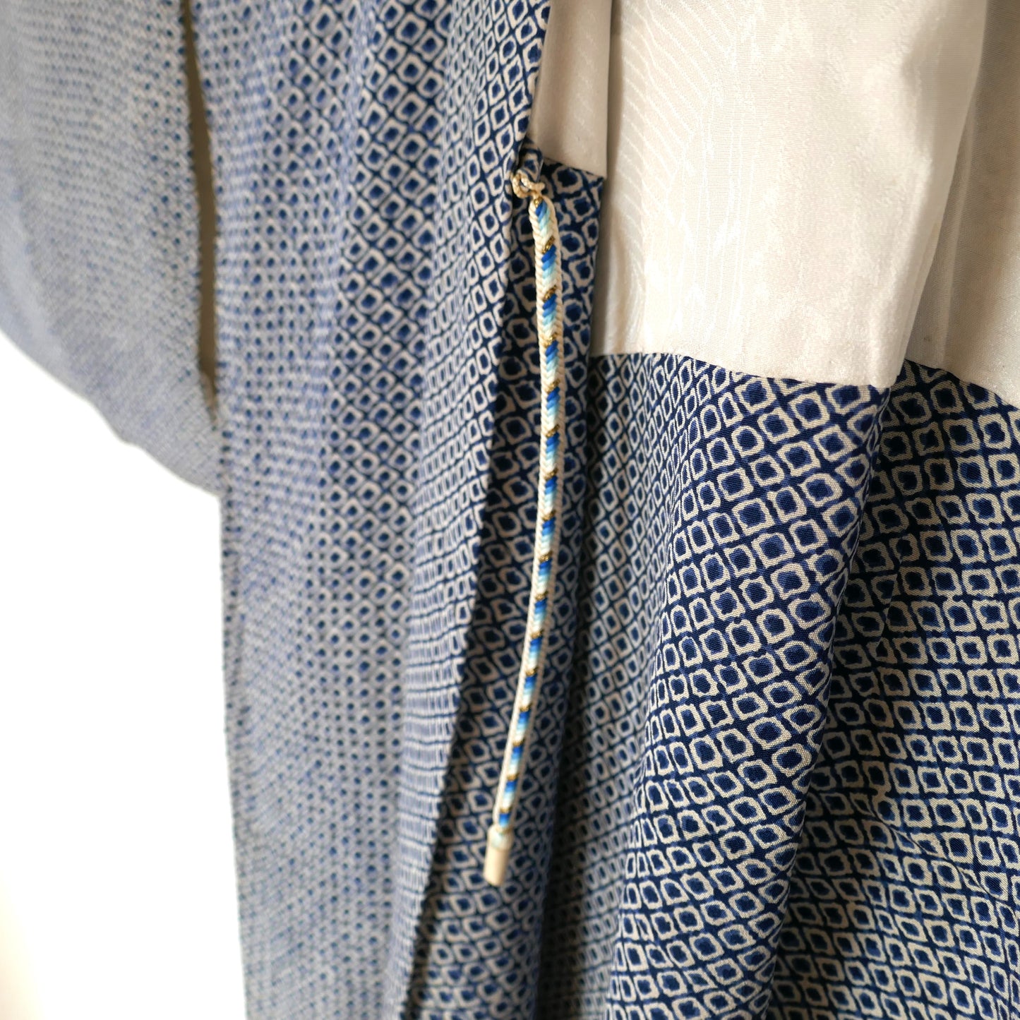Attache traditionnelle haori himo 羽織紐 bicolore en bleu clair et foncé sur un haori vintage.