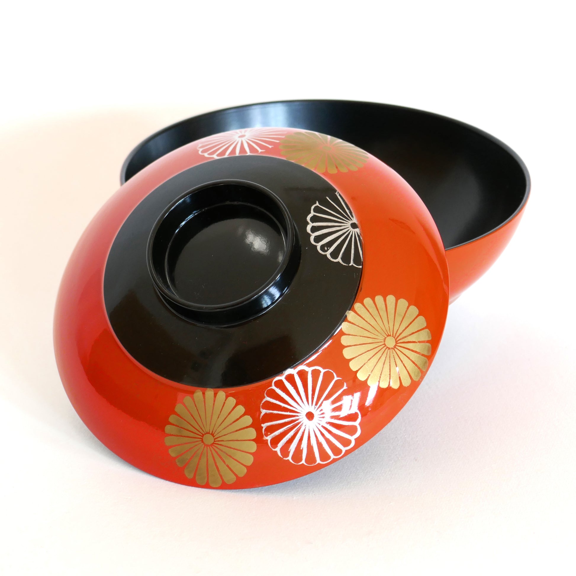 Bol laqué d’Aizu avec le couvercle légèrement déplacé, dévoilant l’intérieur noir profond