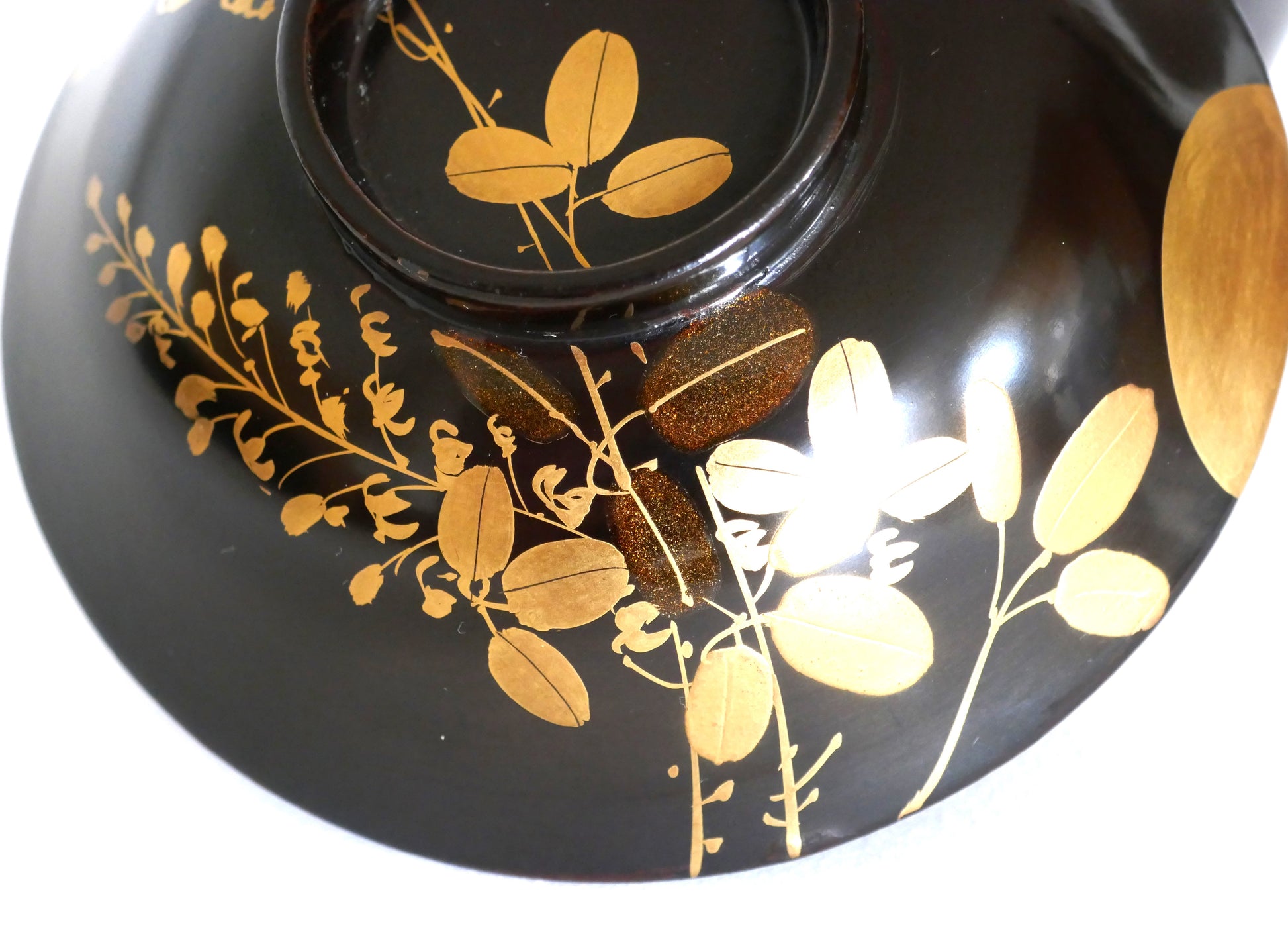 Détail du décor floral doré sur le couvercle du bol en laque japonaise, feuilles de hagi
