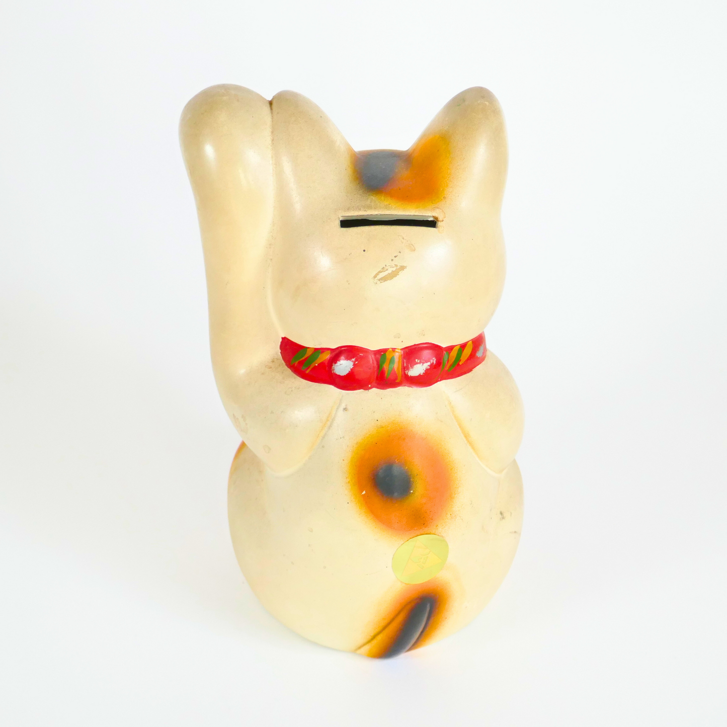 un chat japonais porte bonheur maneki neko de dos avec un trou de tirelire