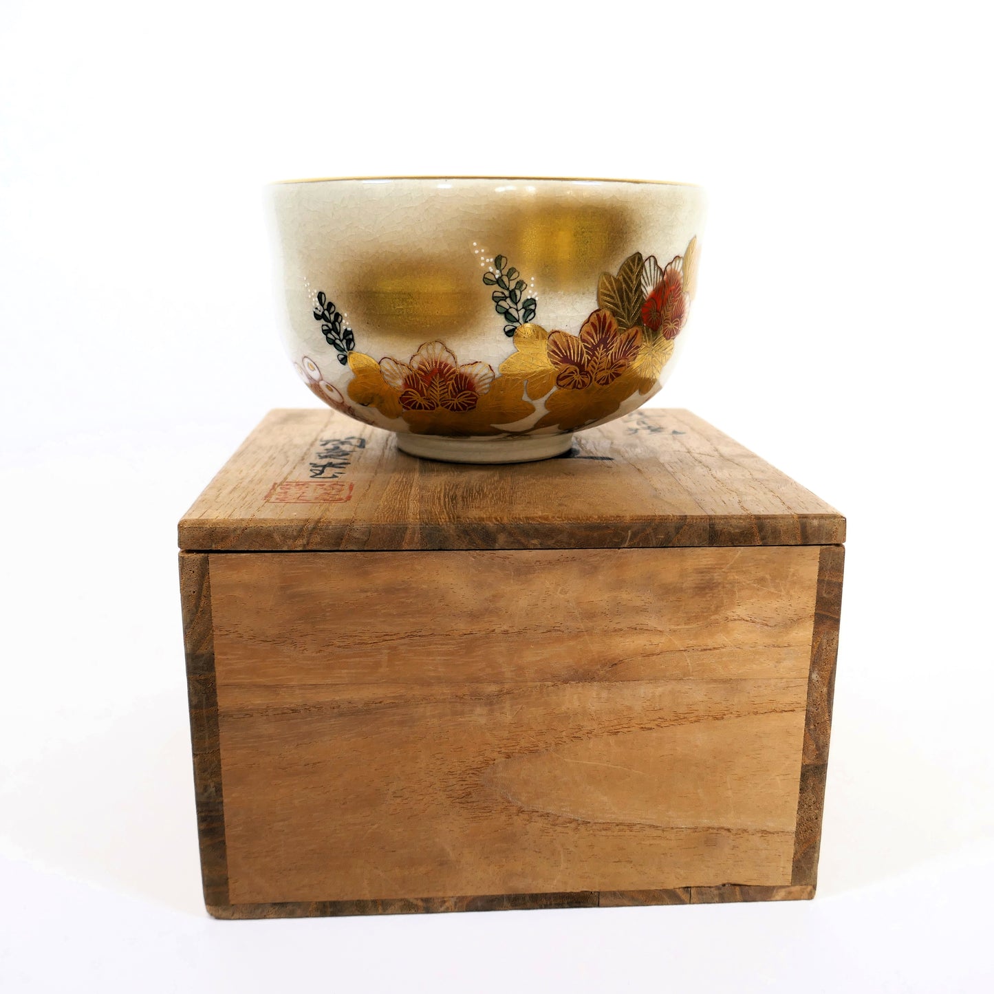 Bol à thé japonais Kutani avec décor floral doré posé sur sa boîte en bois calligraphiée