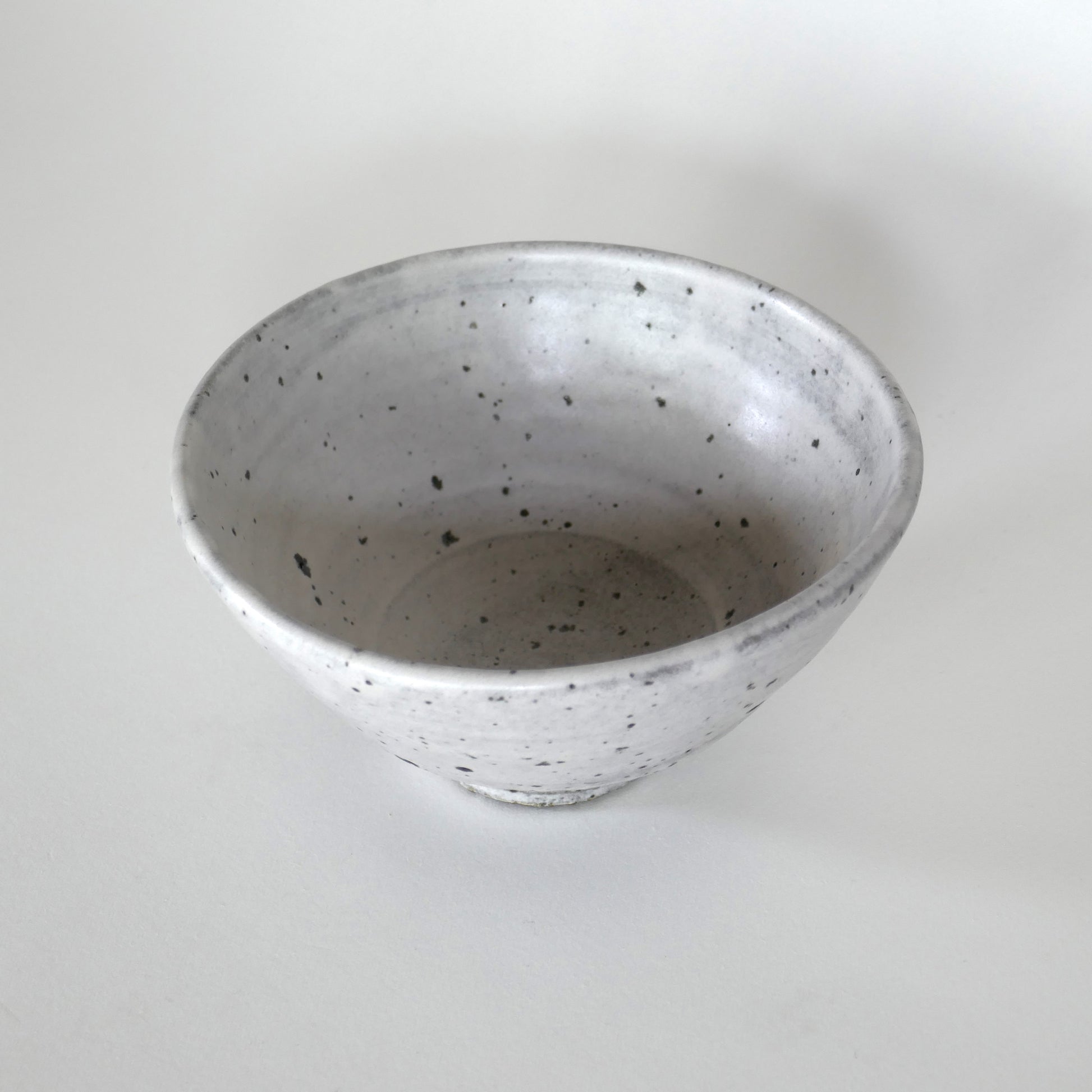 Vue plongeante en légère diagonale, soulignant la profondeur du bol et sa glaçure blanche vivante.