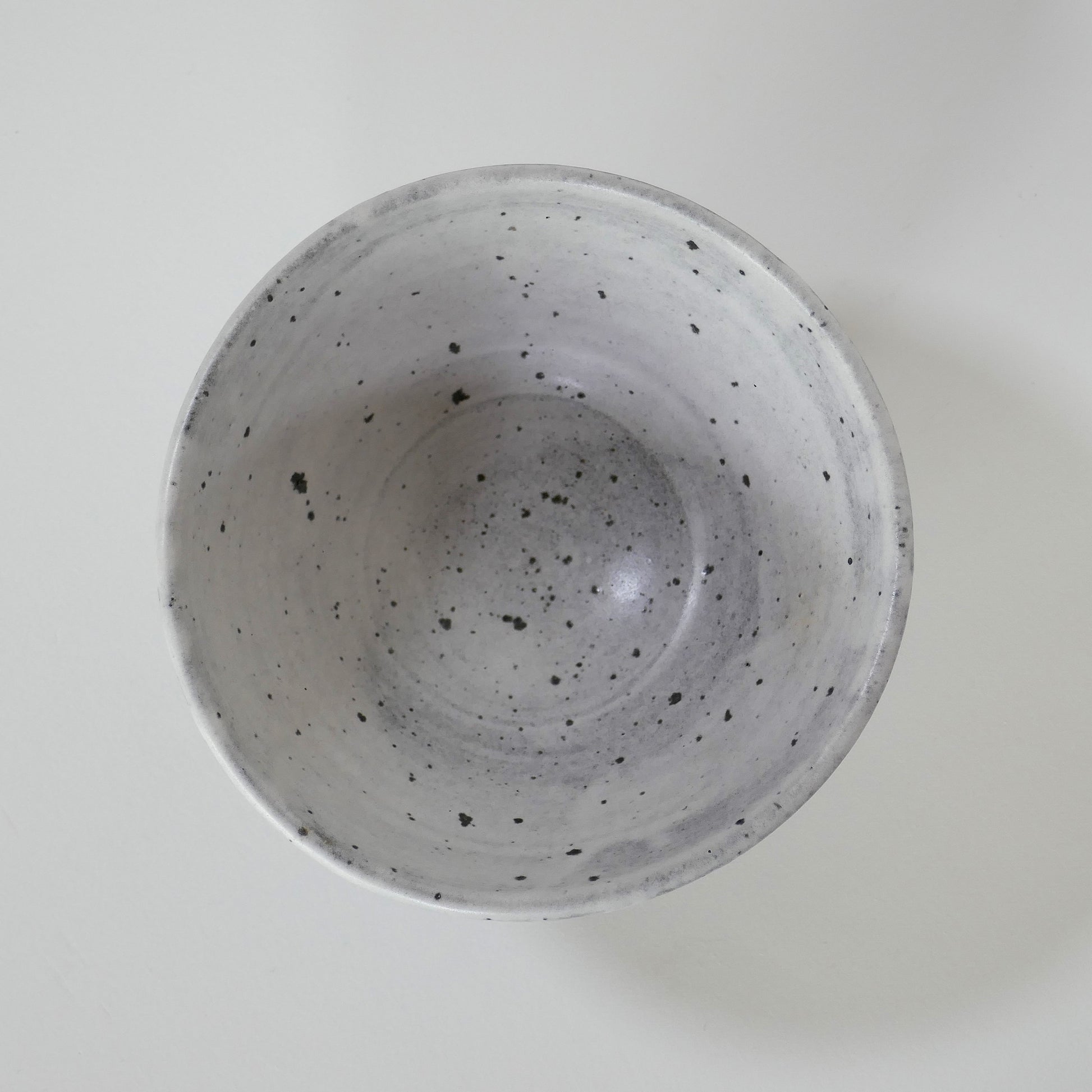 Intérieur du chawan montrant la régularité du tournage et les points ferreux naturels de la glaçure mate.