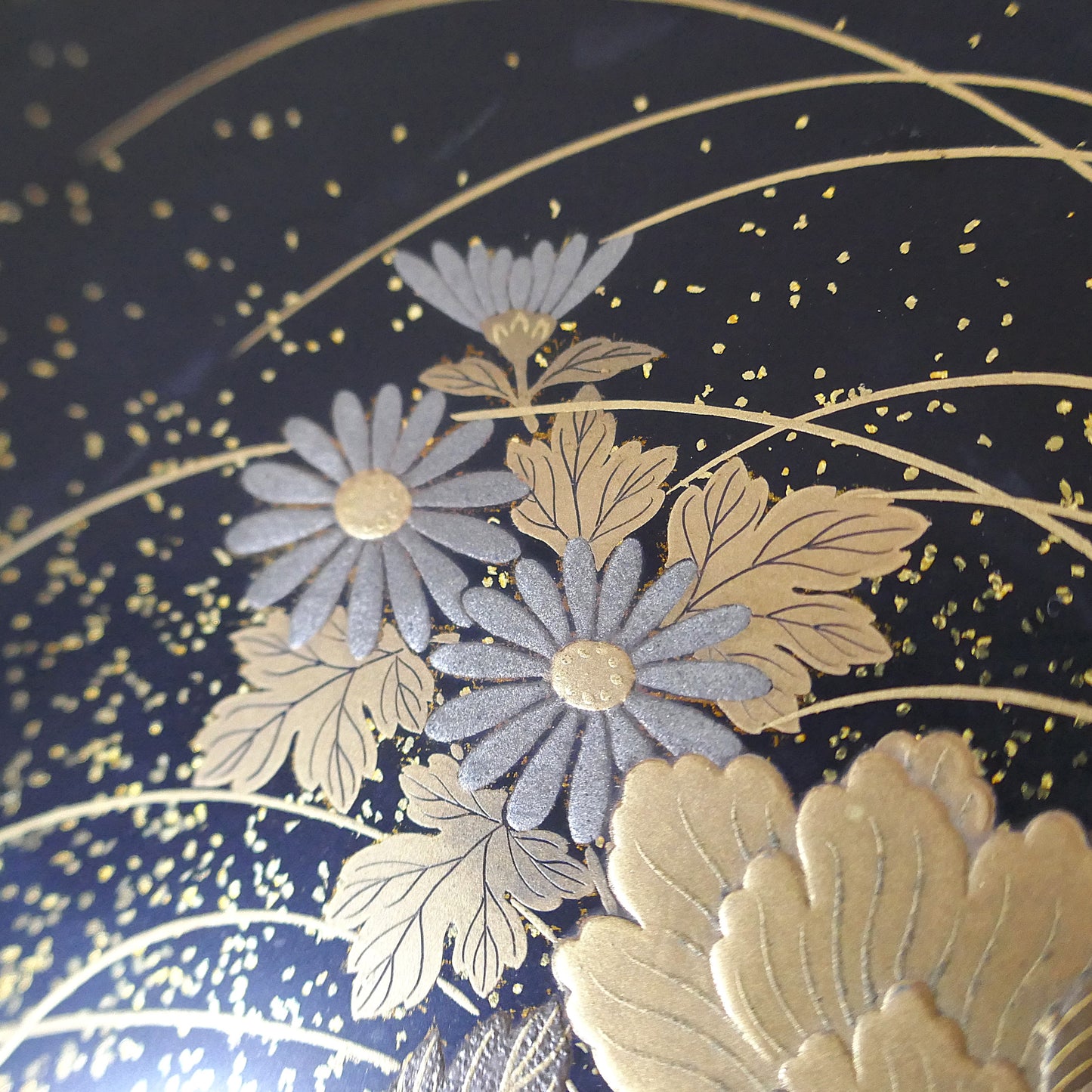 Fleurs de chrysanthèmes bleutées en relief sur boîte laquée noire, motif maki-e raffiné, artisanat Zohiko Kyoto.