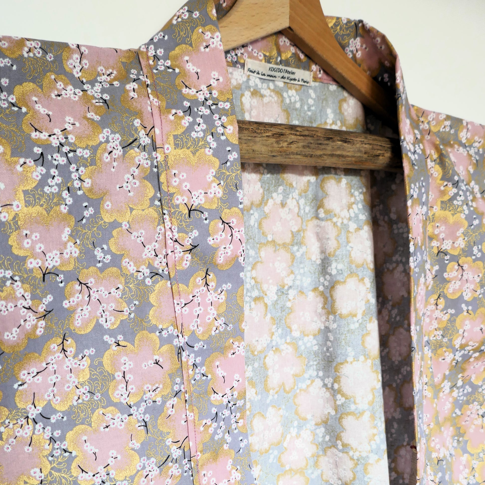 Zoom sur le col du haori Sakura Fubuki, tissu japonais imprimé de fleurs de cerisier dorées sur fond gris pastel