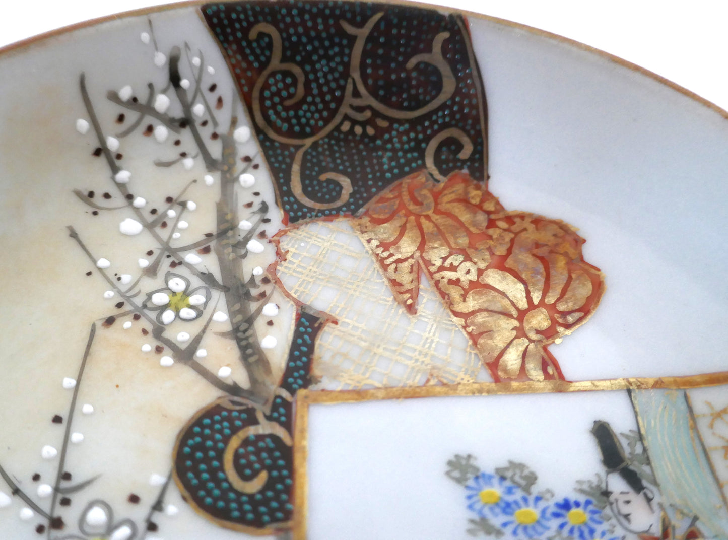 Détail des dorures et motifs textiles traditionnels peints à la main sur une assiette Kutani ancienne