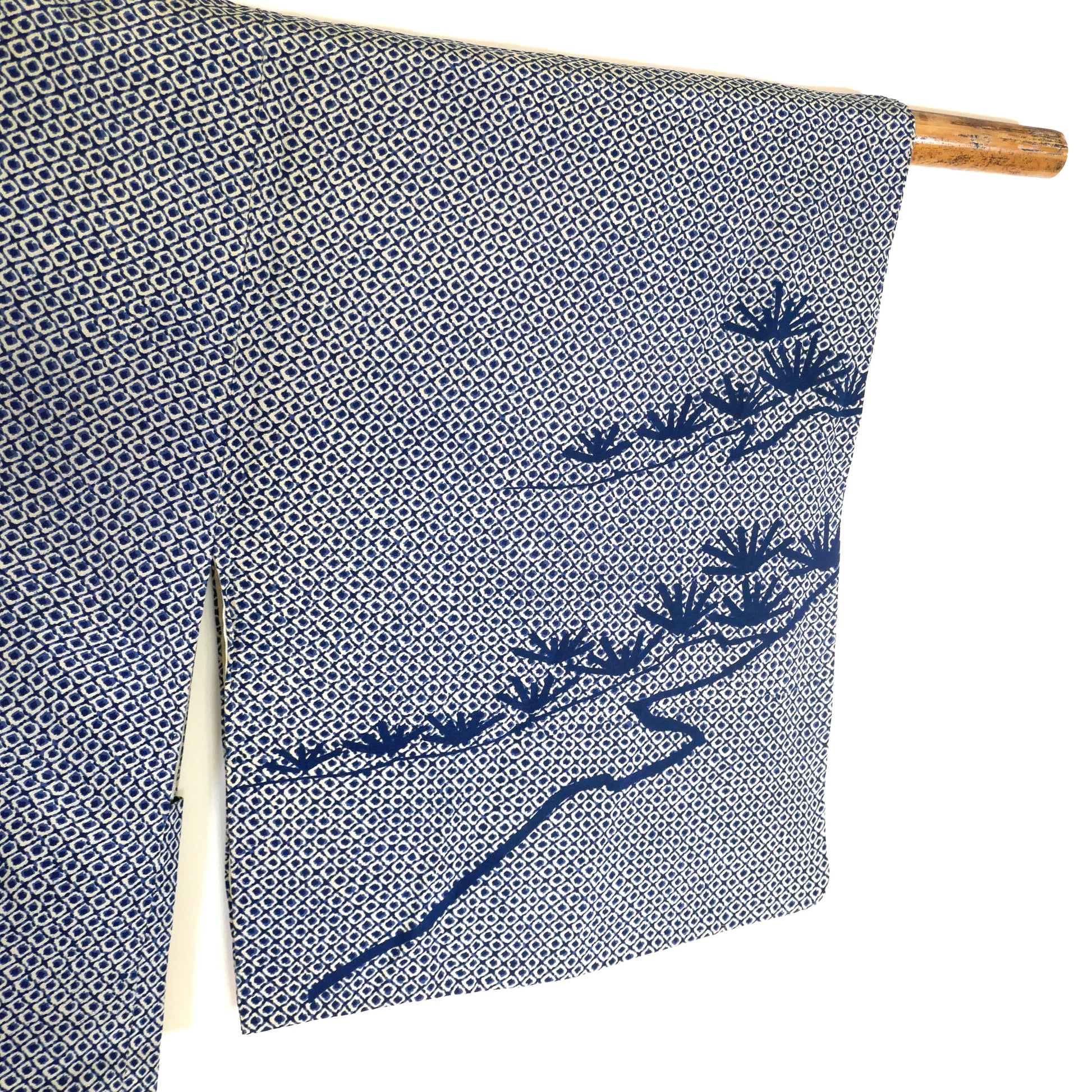 Zoom sur la soie à motif shibori avec branche de pin stylisée sur un haori japonais.