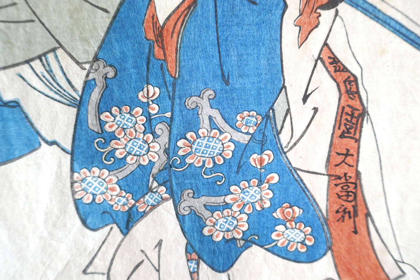 Détail du kimono bleu fleuri porté par la fille d’Awa no Jūrōbei dans l’estampe de Kuniyoshi.