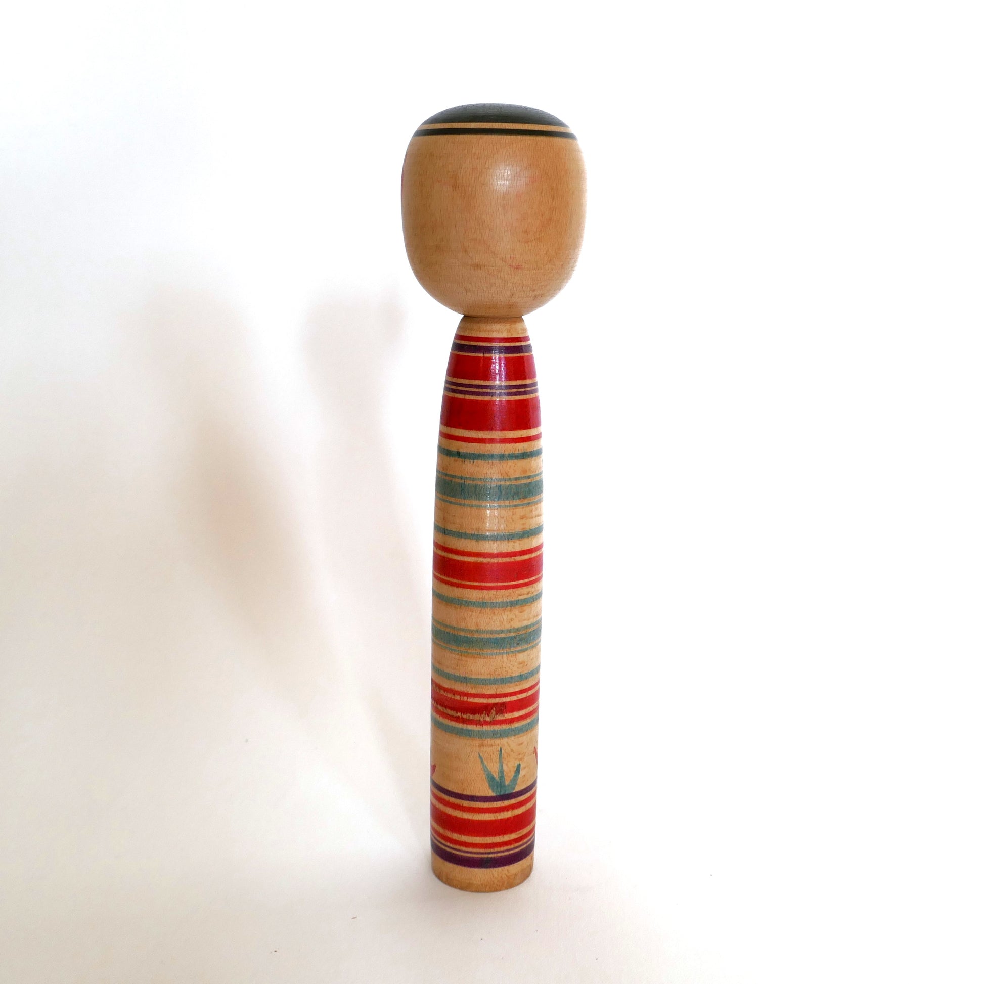 Vue de dos d’une poupée kokeshi traditionnelle Tsuchiyu, artisanat en bois tourné signé Watanabe Sadami, Japon.