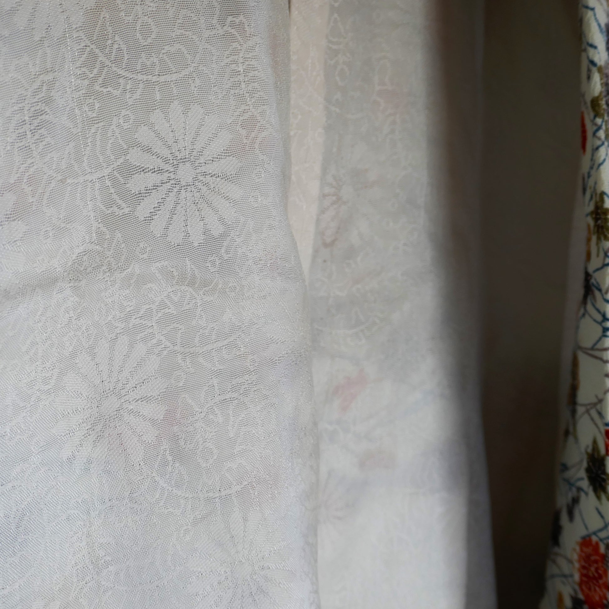 Doublure intérieure en soie blanche d’un haori japonais vintage, décorée de chrysanthèmes 菊 en ton sur ton.