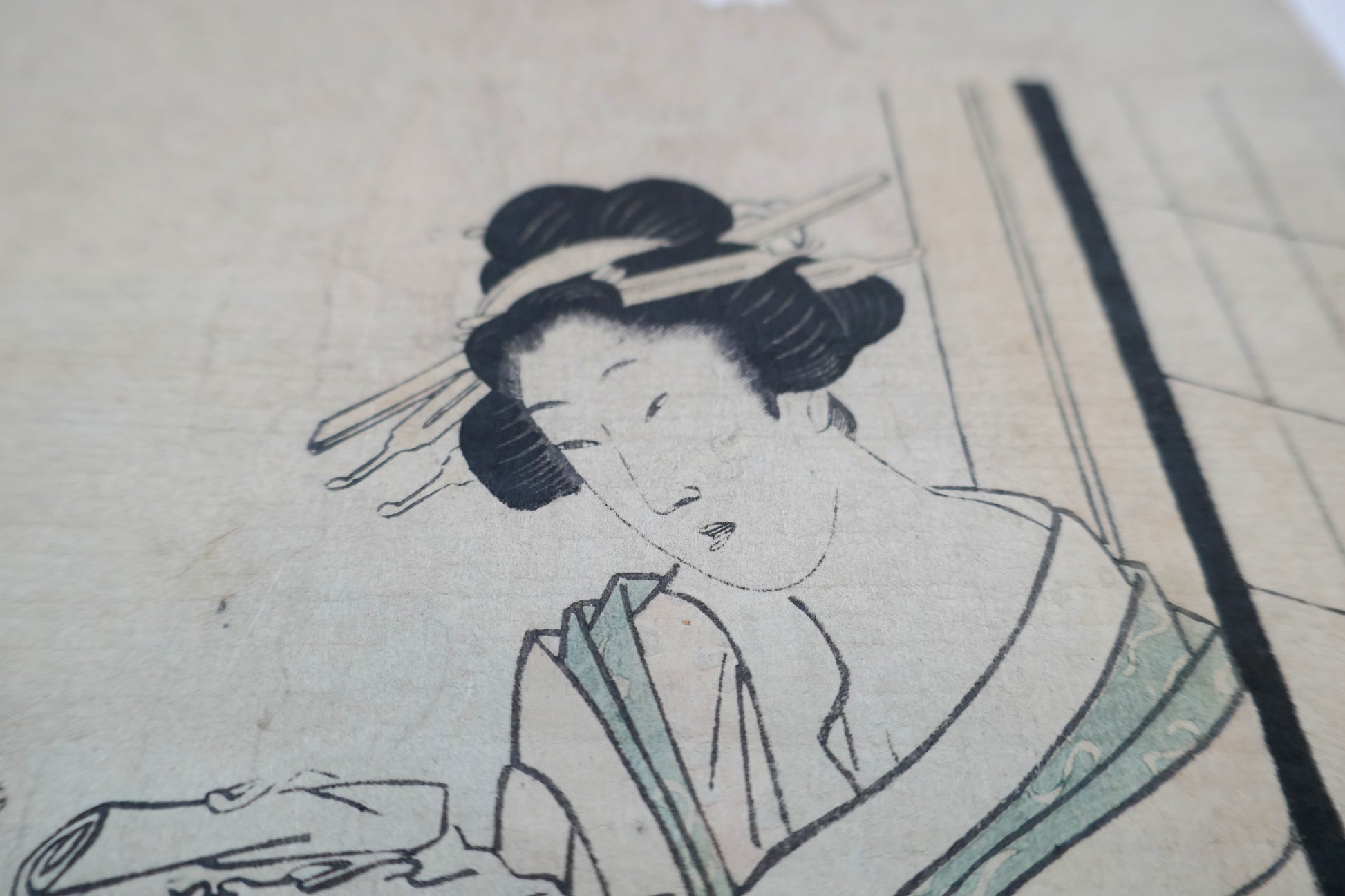 Zoom sur la courtisane de droite tenant un rouleau dans une estampe bijin-ga signée Kikugawa Eizan.