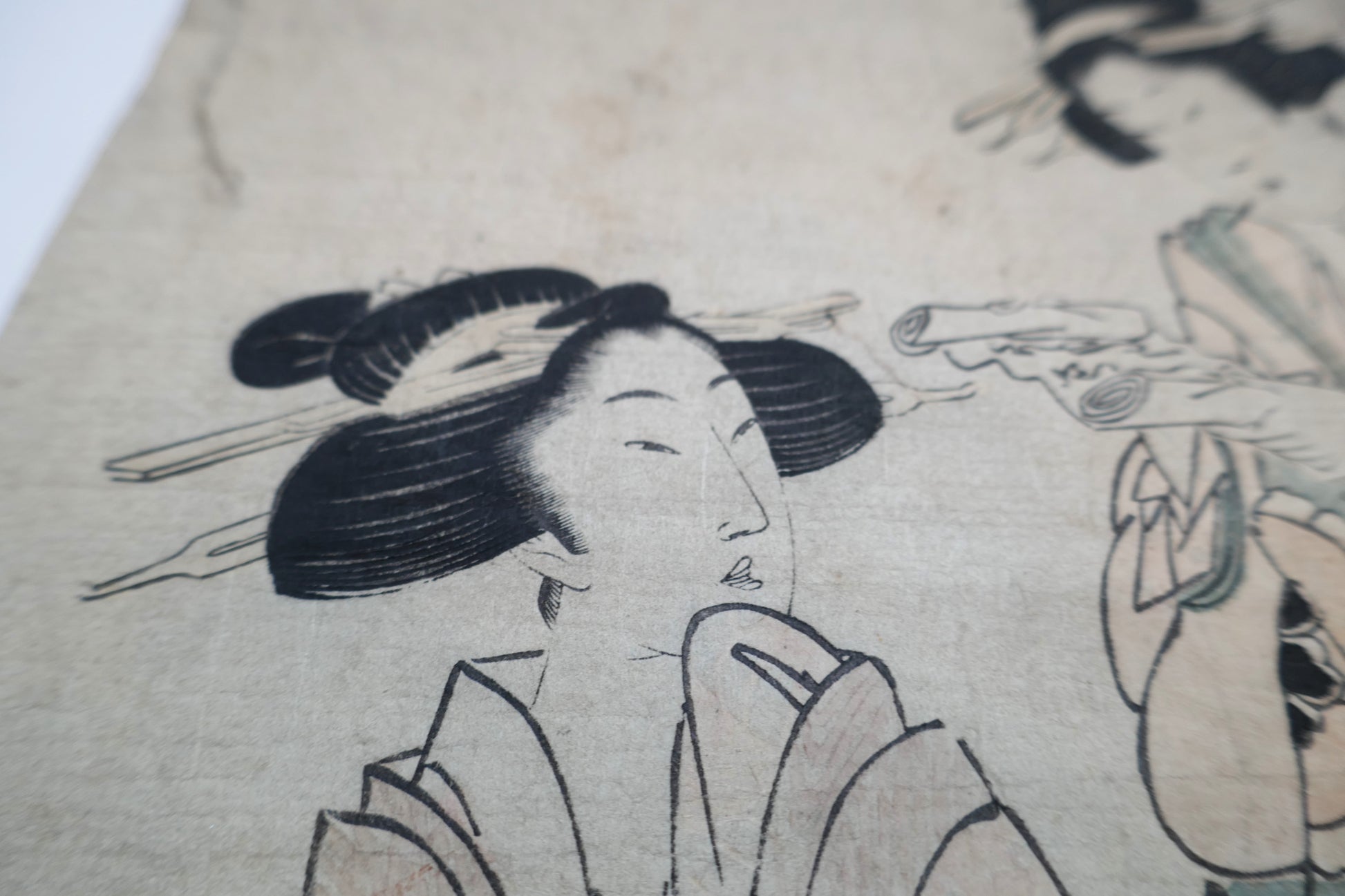 Gros plan sur le visage de la courtisane de gauche dans une estampe bijin-ga d'Eizan, coiffure traditionnelle avec kanzashi.