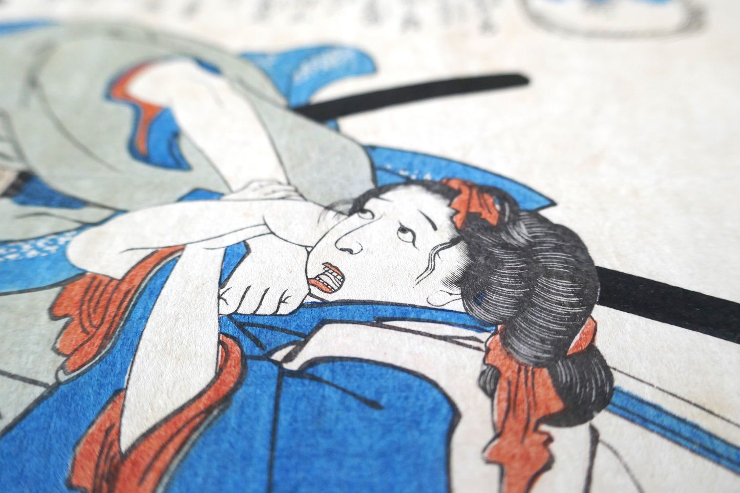 Gros plan sur le profil effrayé de la jeune fille dans l’estampe de Kuniyoshi représentant une scène tragique.