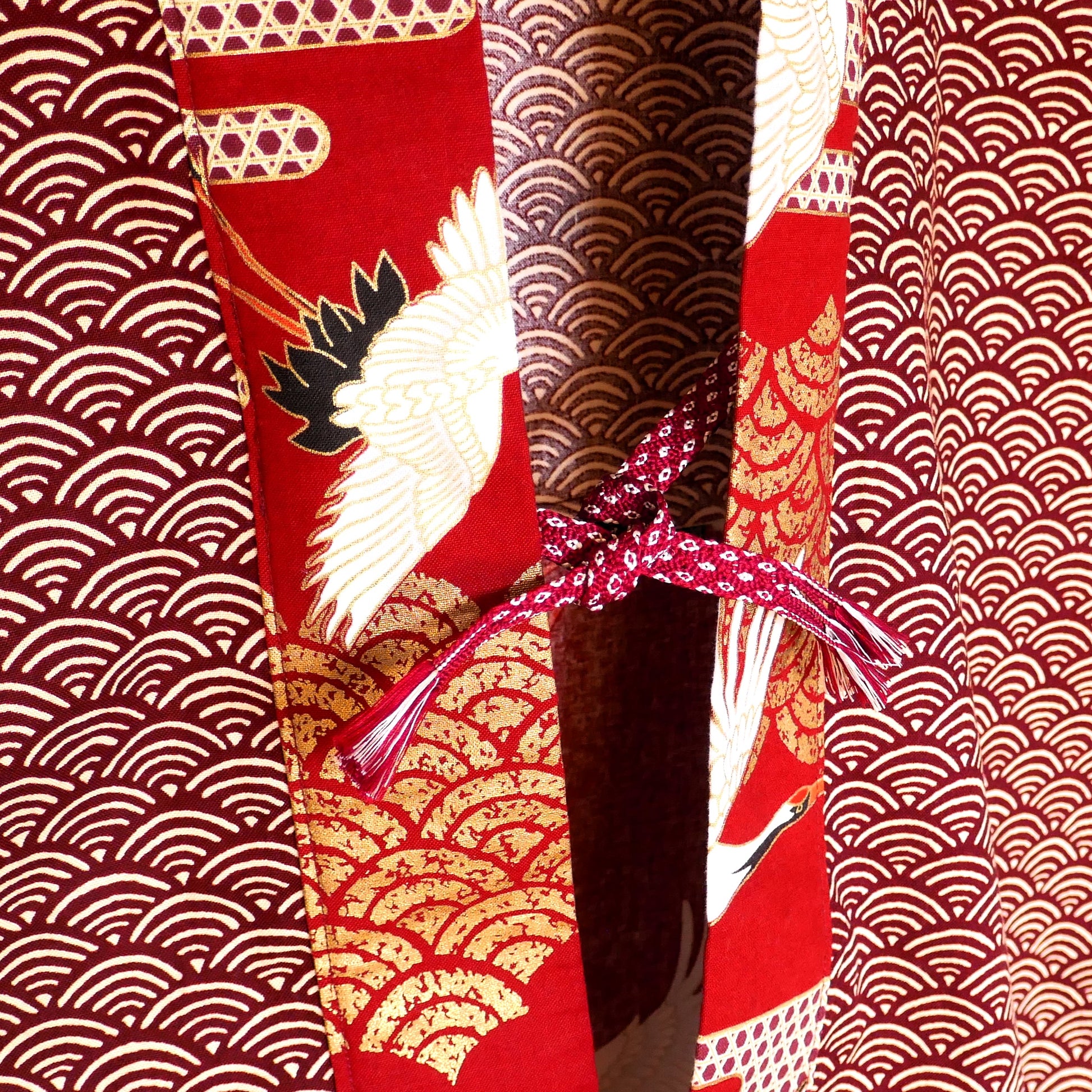 Intérieur du haori Akane Tsuru montrant les finitions artisanales et le lien de fermeture traditionnel obihimo obijime en corde tressée rouge.