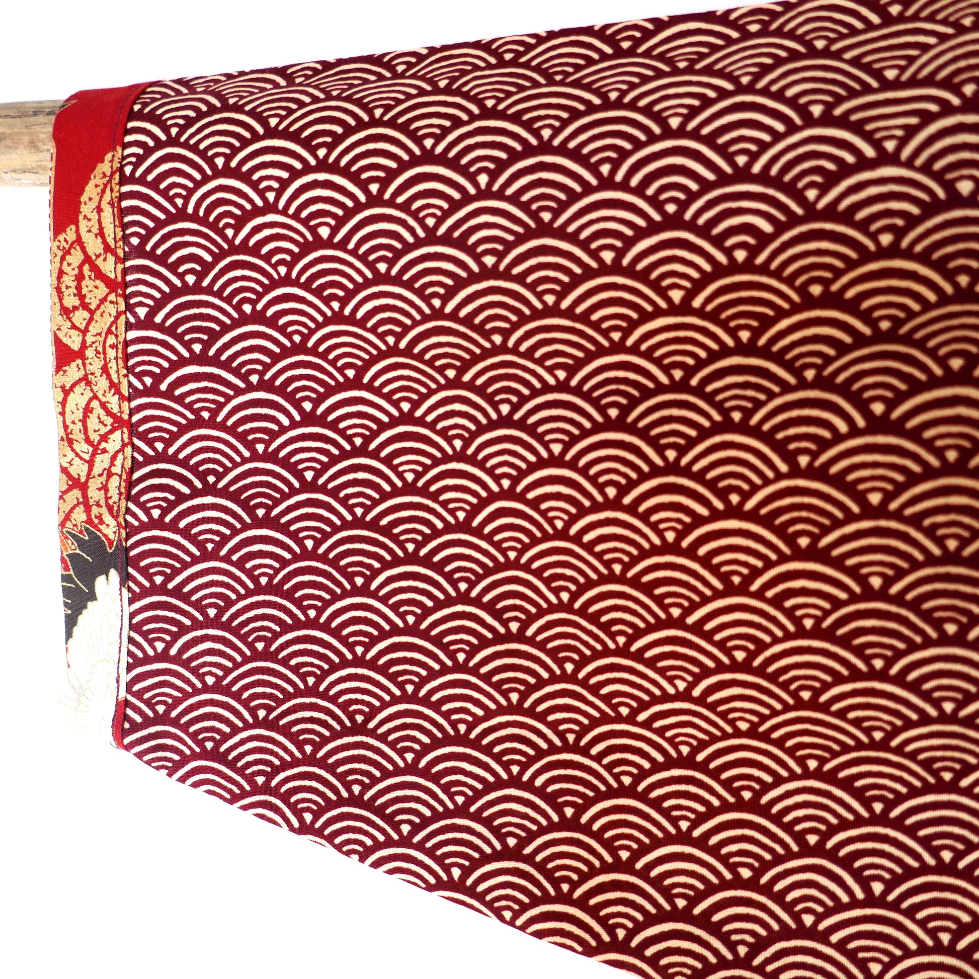 Zoom sur la manche du haori Akane Tsuru, montrant le motif traditionnel seigaiha rouge évoquant les vagues japonaises.