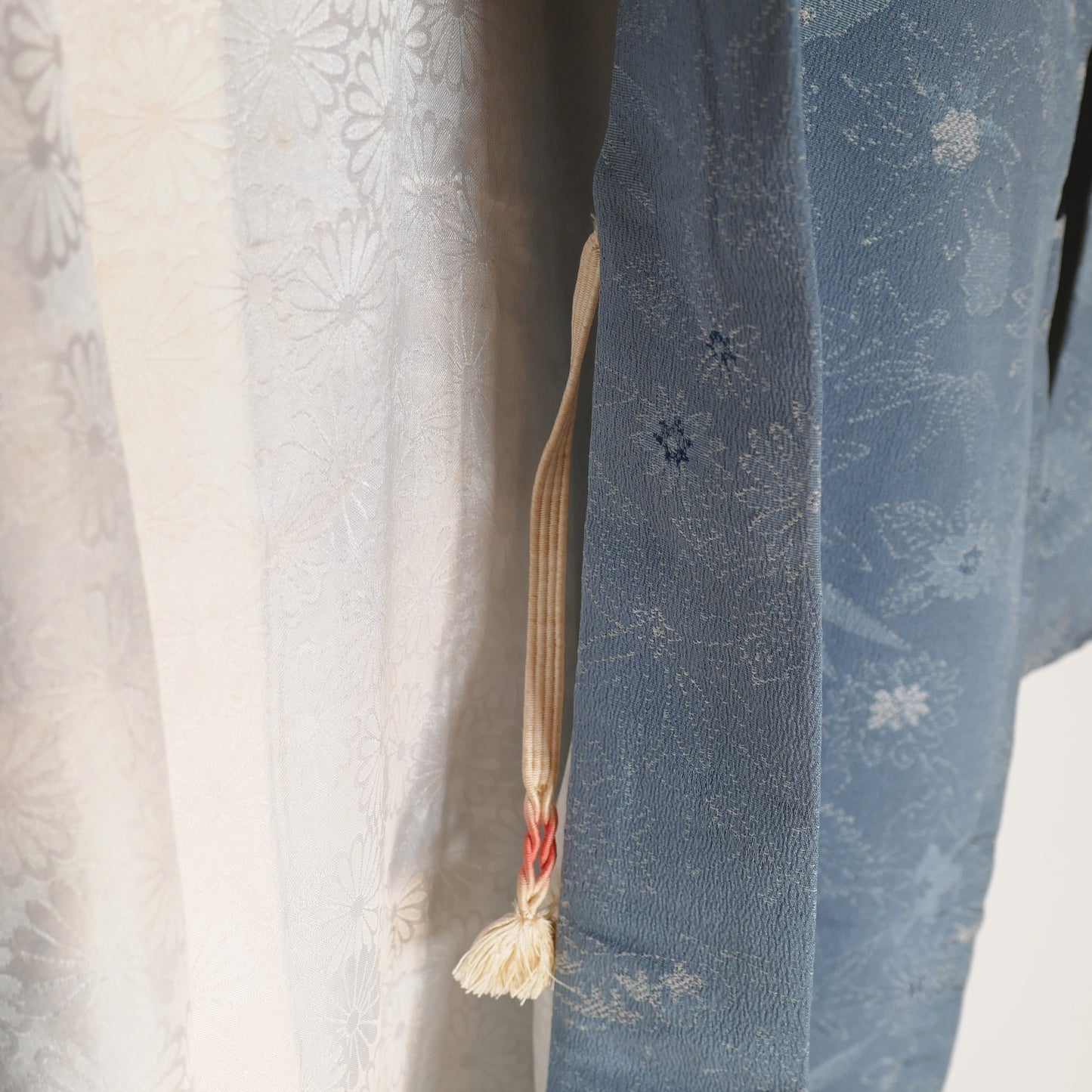 Zoom sur le col d’un haori en soie bleu ciel avec motifs floraux japonais, doublé de chrysanthèmes blancs (kiku 菊).