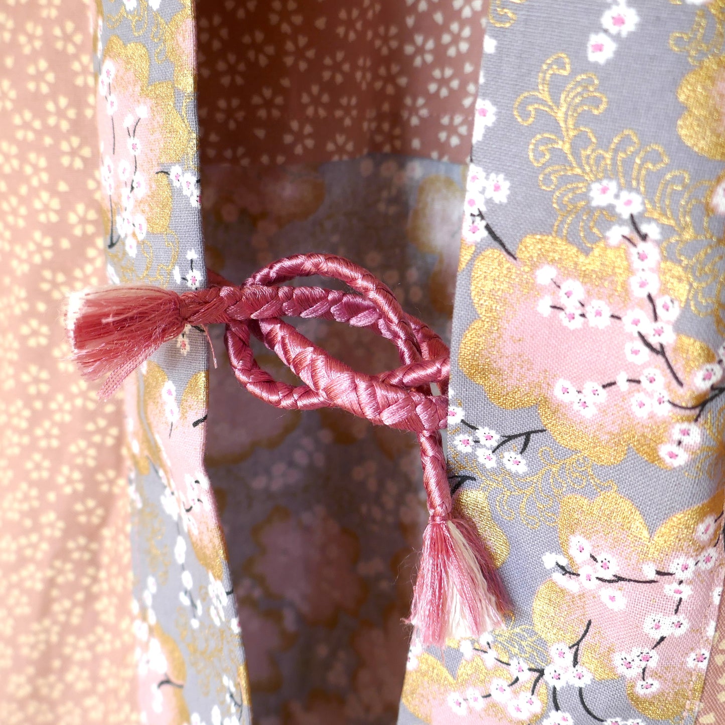 Attache traditionnelle obihimo tressée du haori Hanami, en corde rose pâle assortie.