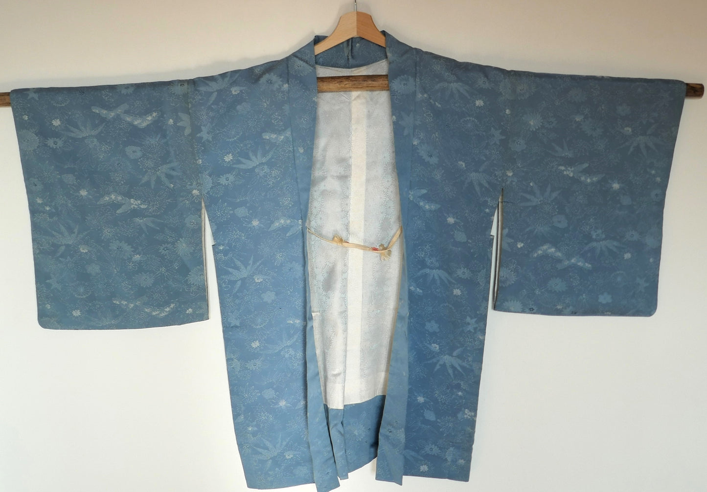 Vue de faec du haori japonais en soie bleu clair avec motifs de feuilles stylisées et fleurs en ton sur ton.