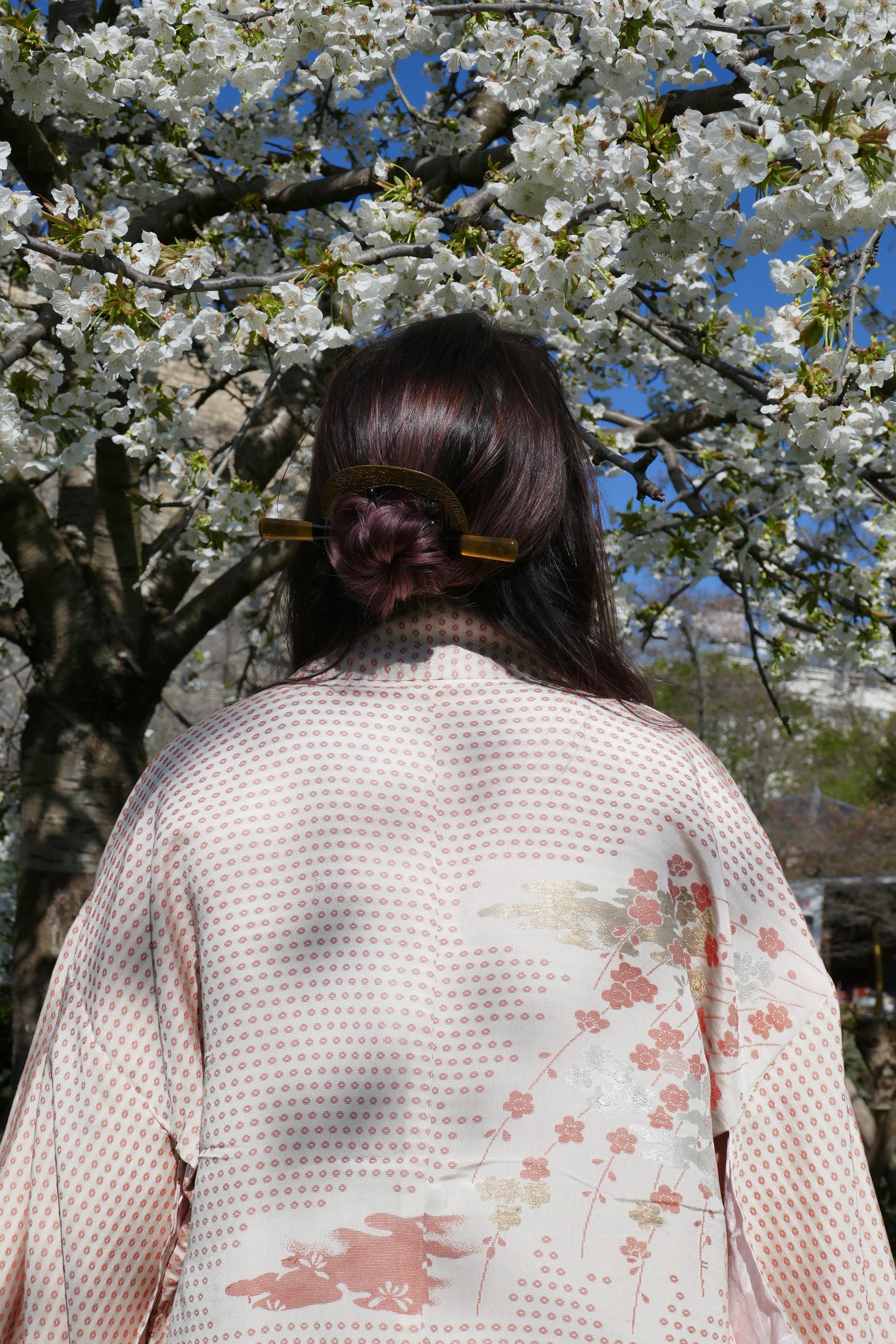 Zoom sur l’arrière du haori à motifs floraux et la coiffure de Mikan avec kushi et kogai imitation écaille de tortue.