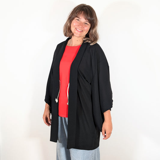 Haori japonais authentique en soie noire monsha porté sur une tenue contemporaine, veste kimono légère à motif ichimatsu.