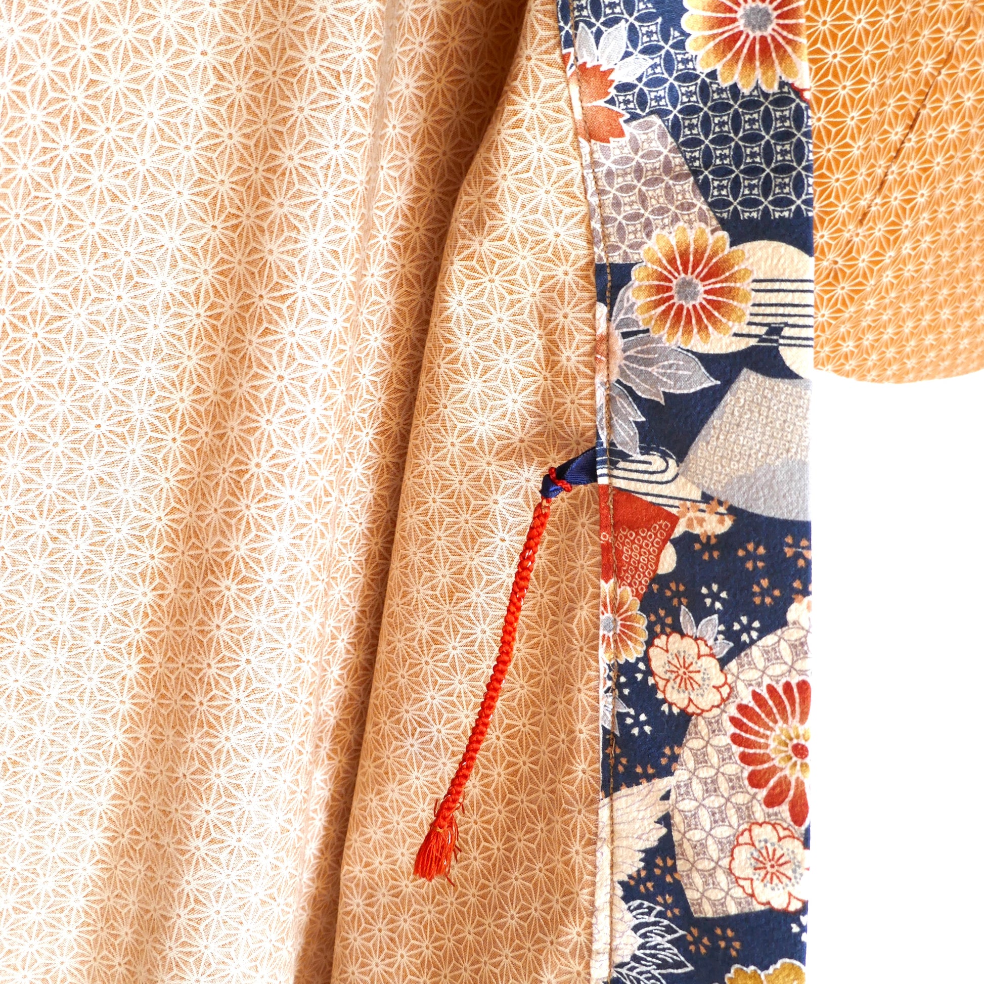 Détail de l'attache traditionnelle haori himo rouge du modèle Yūyake Zakura