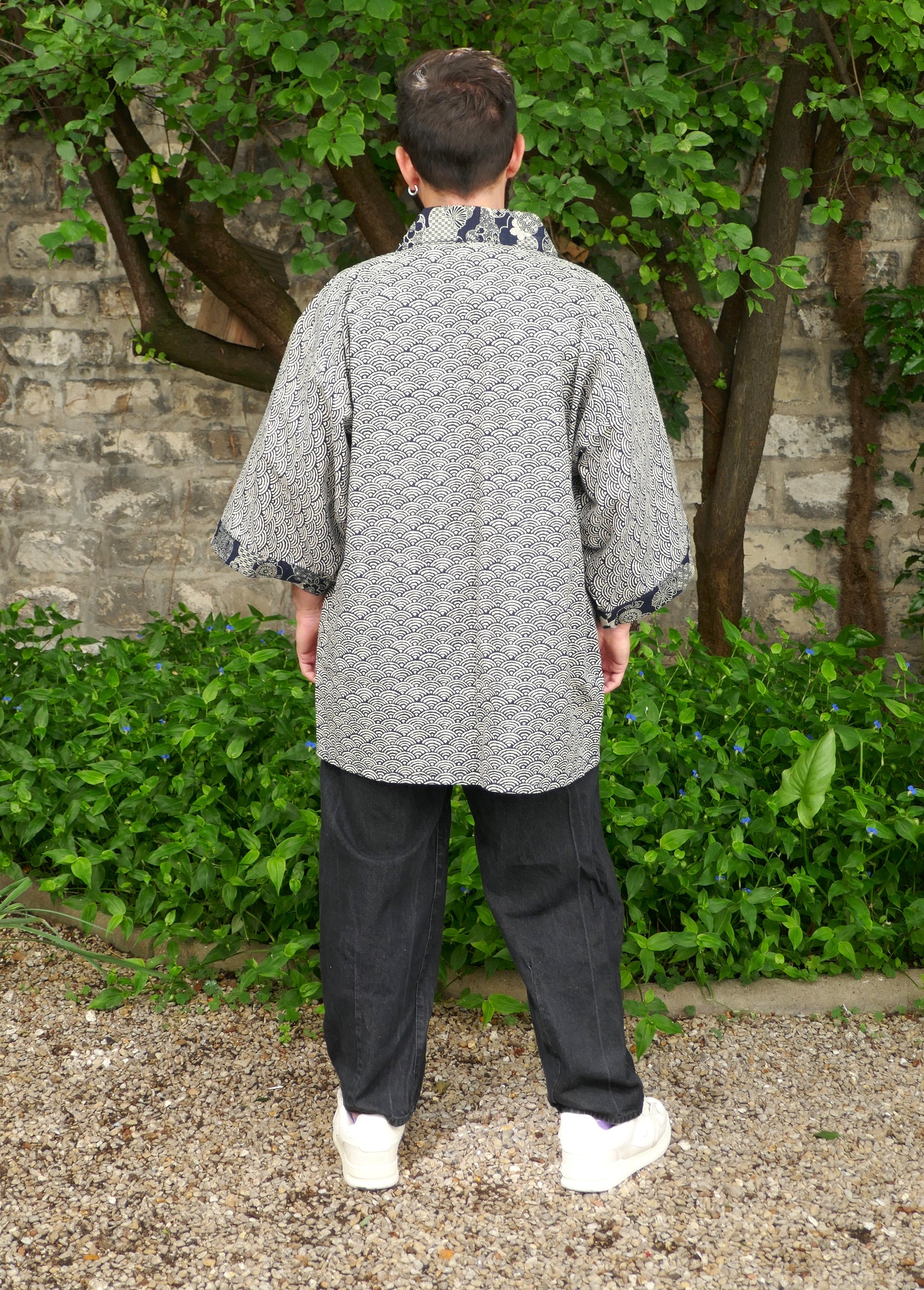 Toma vu de dos dans le haori mixte “Umi no Sakura”, confection artisanale KOGEDO. Design raffiné avec motif de vagues japonaises et finitions florales sur col et poignets. Look zen et structuré.