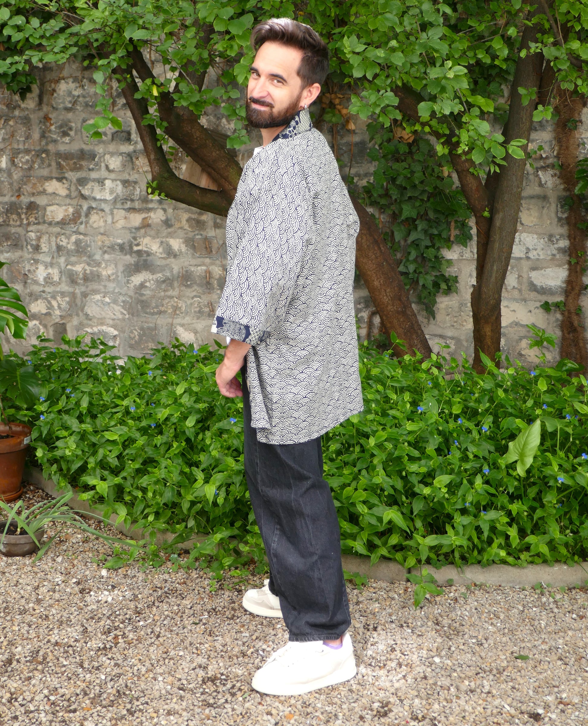 Toma de profil en haori japonais “Umi no Sakura”, vêtement moderne inspiré des textiles traditionnels japonais. Association harmonieuse entre graphisme bleu nuit et blanc et motif sakura pour un look original.