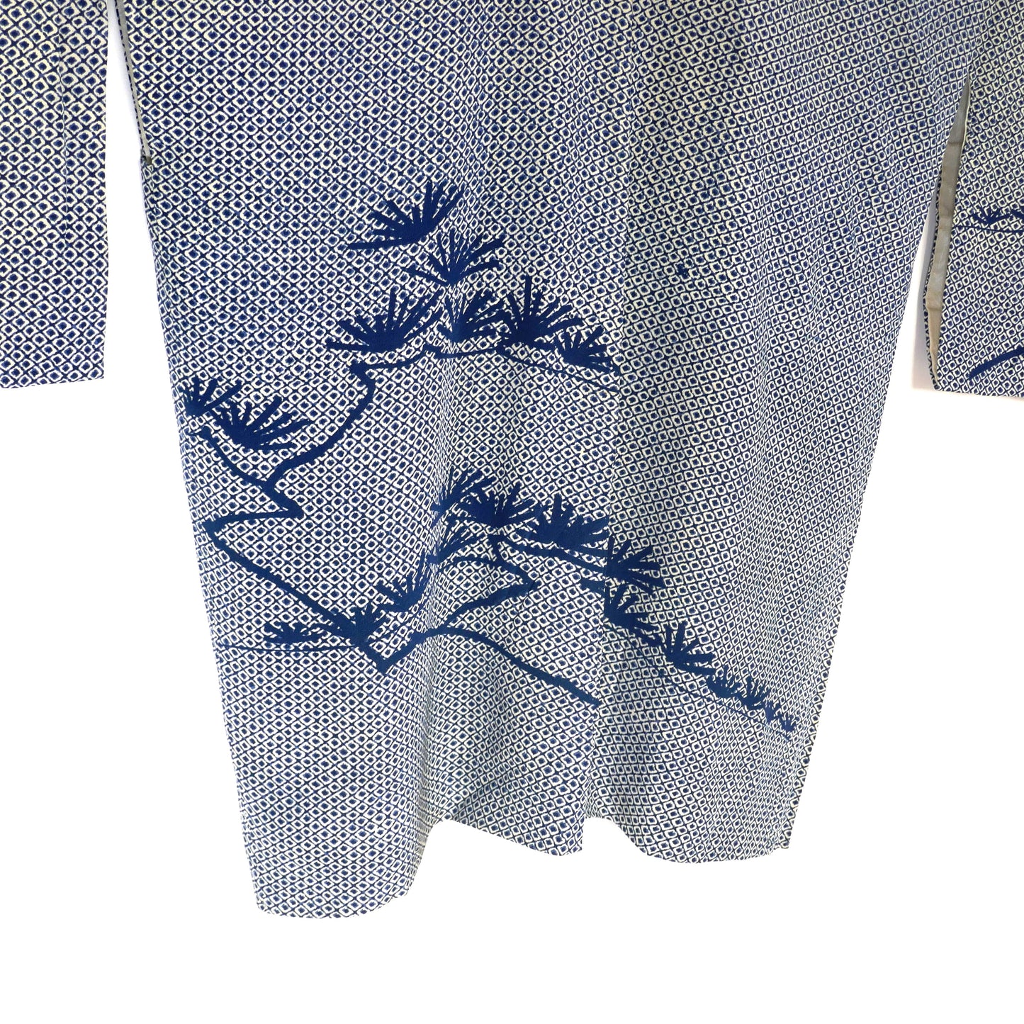 Détail du dos d’un haori shibori avec motifs de pin 松 teints en bleu profond.