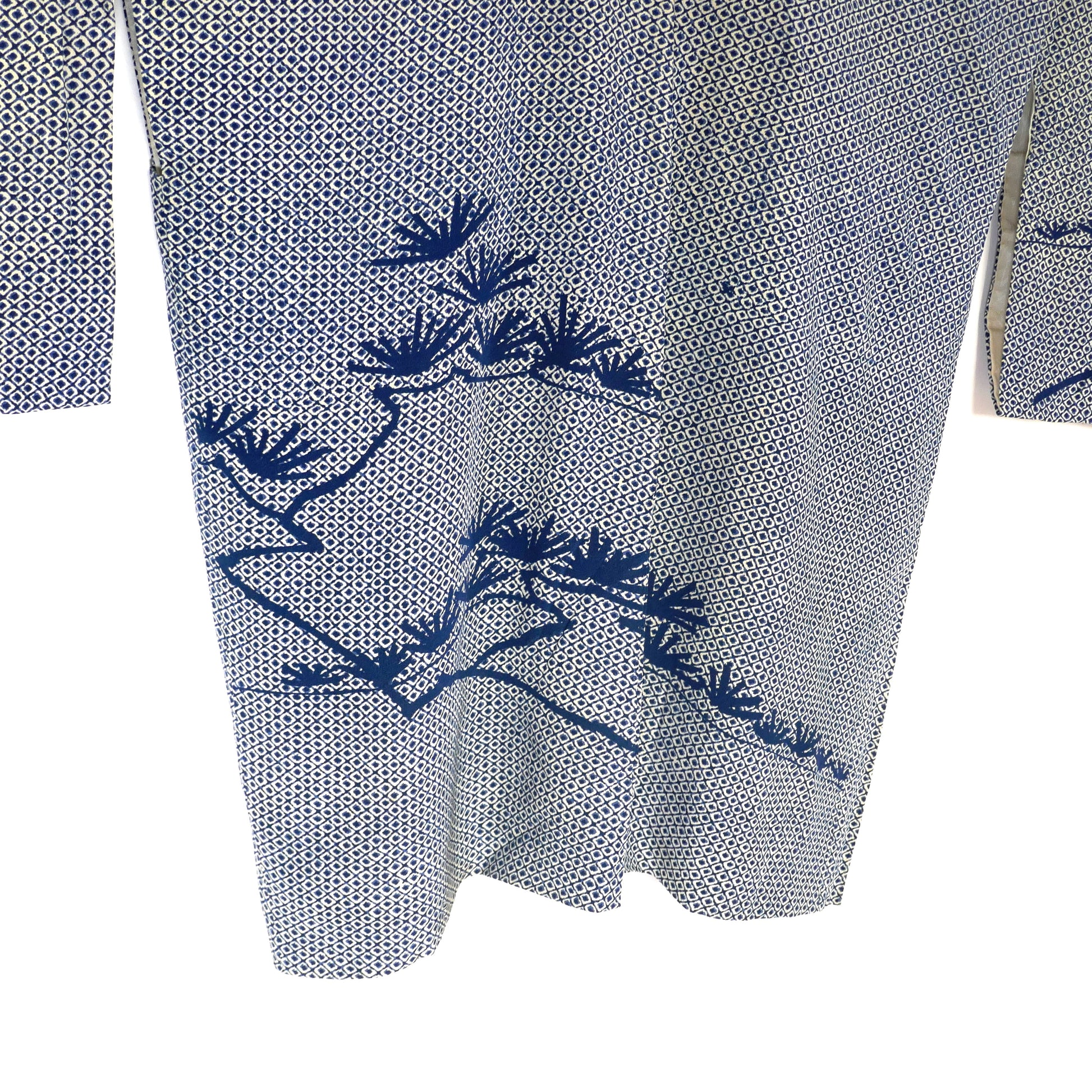 Détail du dos d’un haori shibori avec motifs de pin 松 teints en bleu profond.