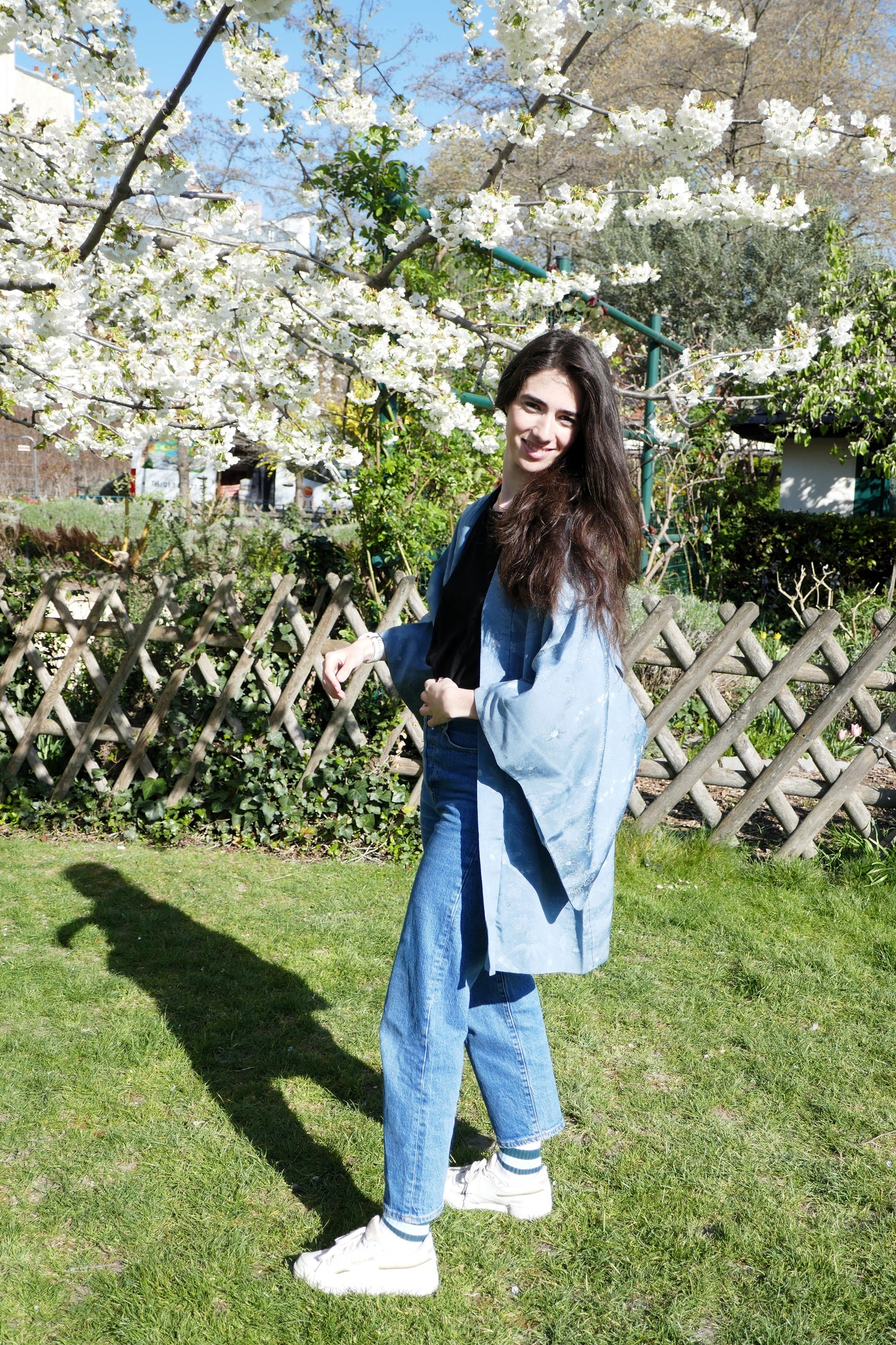 Haori vintage bleu porté par Mayssa, profil ensoleillé dans un jardin fleuri