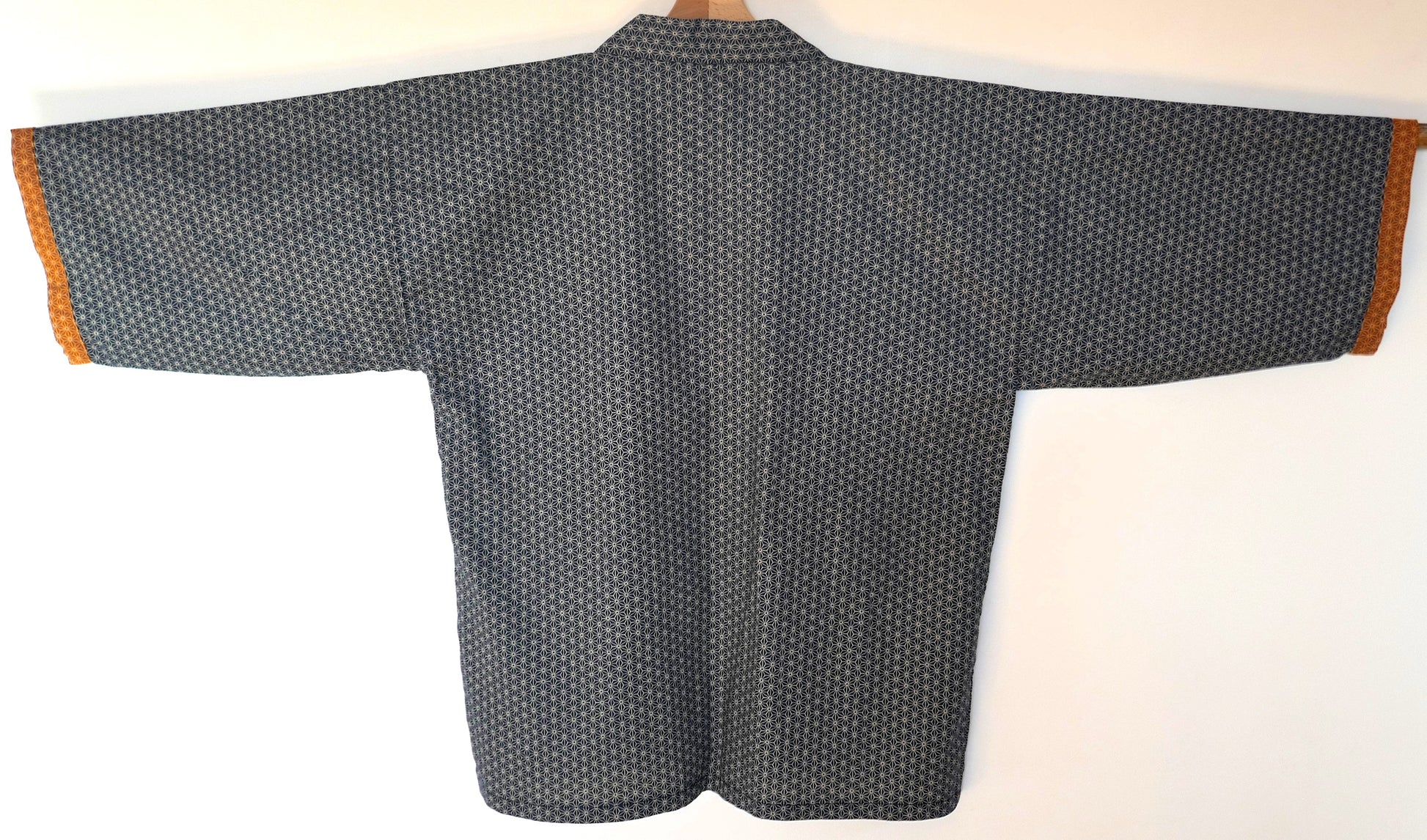 Vue arrière du haori Tradi Tradi de KOGEDO l'Atelier, montrant le motif asanoha bleu marine sur toute la surface, manches à bord ocre.