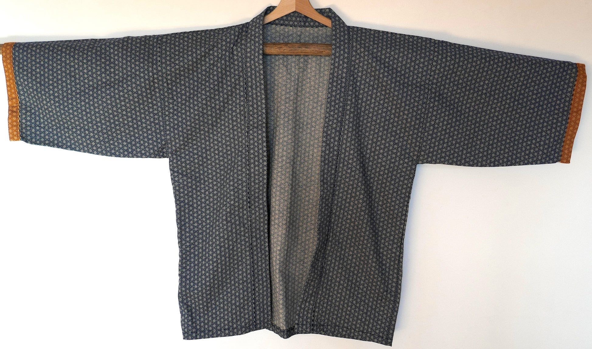 Vue de face du haori japonais Tradi Tradi cousu main par KOGEDO l'Atelier, en coton bleu motif asanoha avec finitions ocre aux manches.