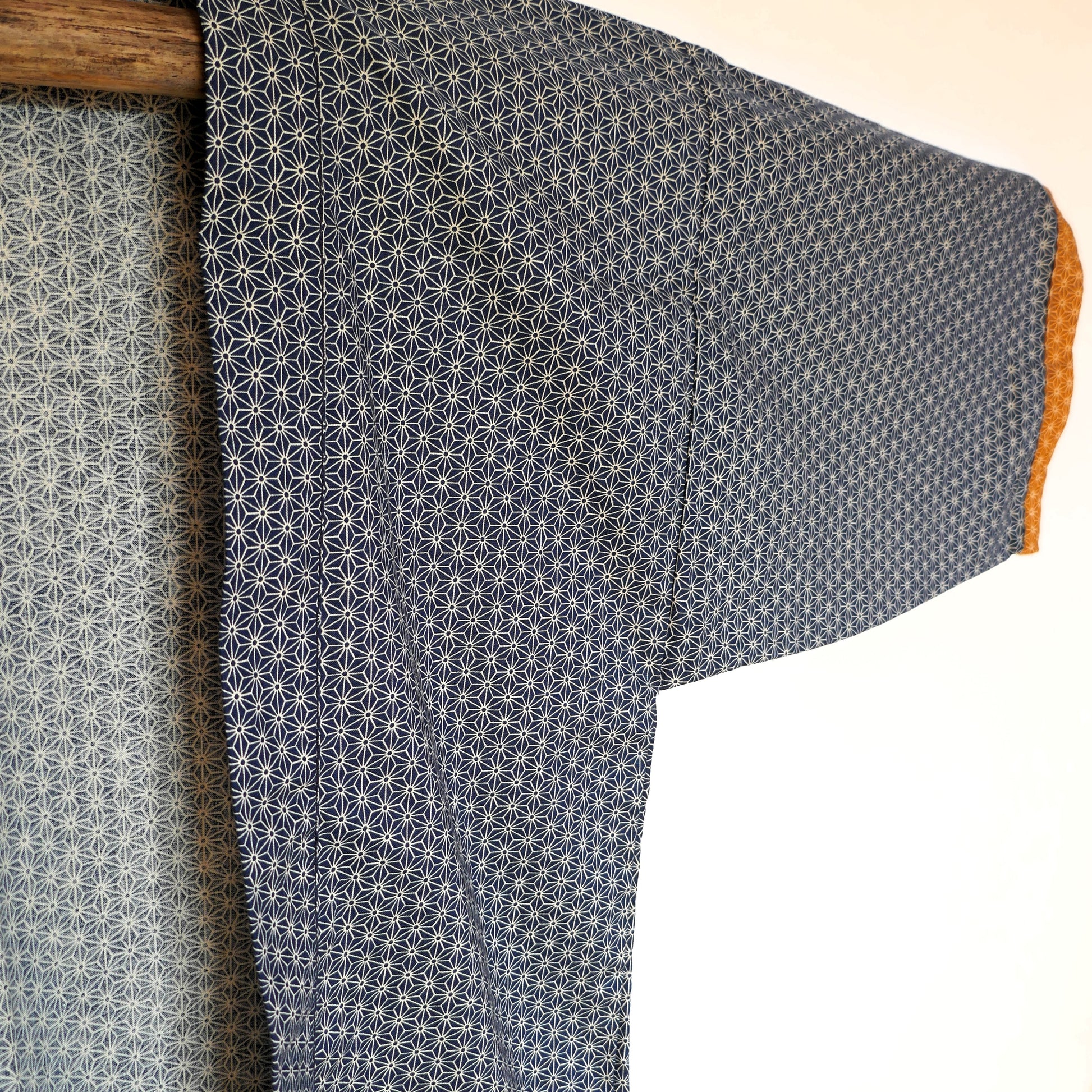 Détail de la manche gauche du haori Tradi Tradi, tissu japonais bleu à motif asanoha et finition contrastée ocre.