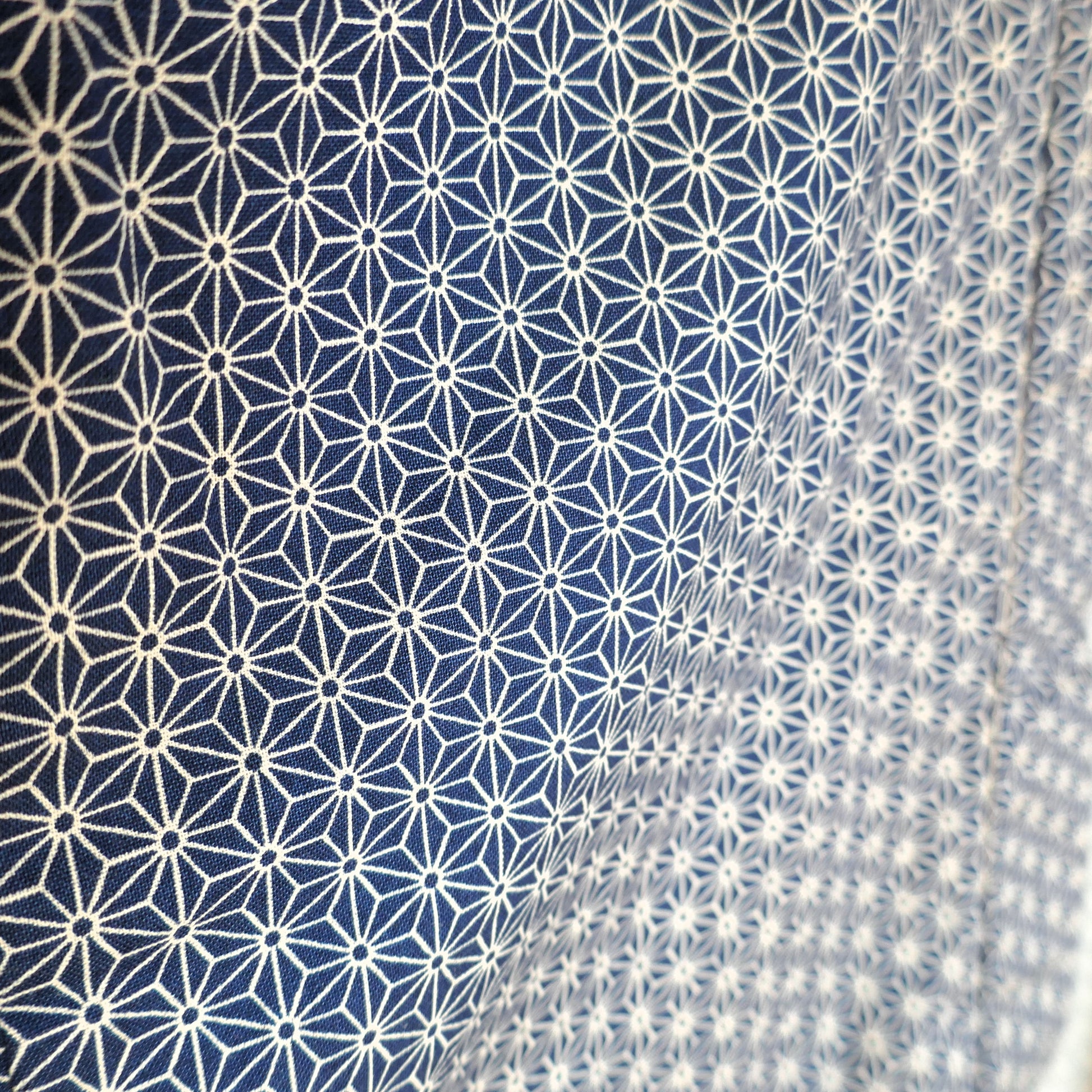 Zoom sur le tissu japonais à motif asanoha du haori Tradi Tradi, en bleu profond et blanc écru.