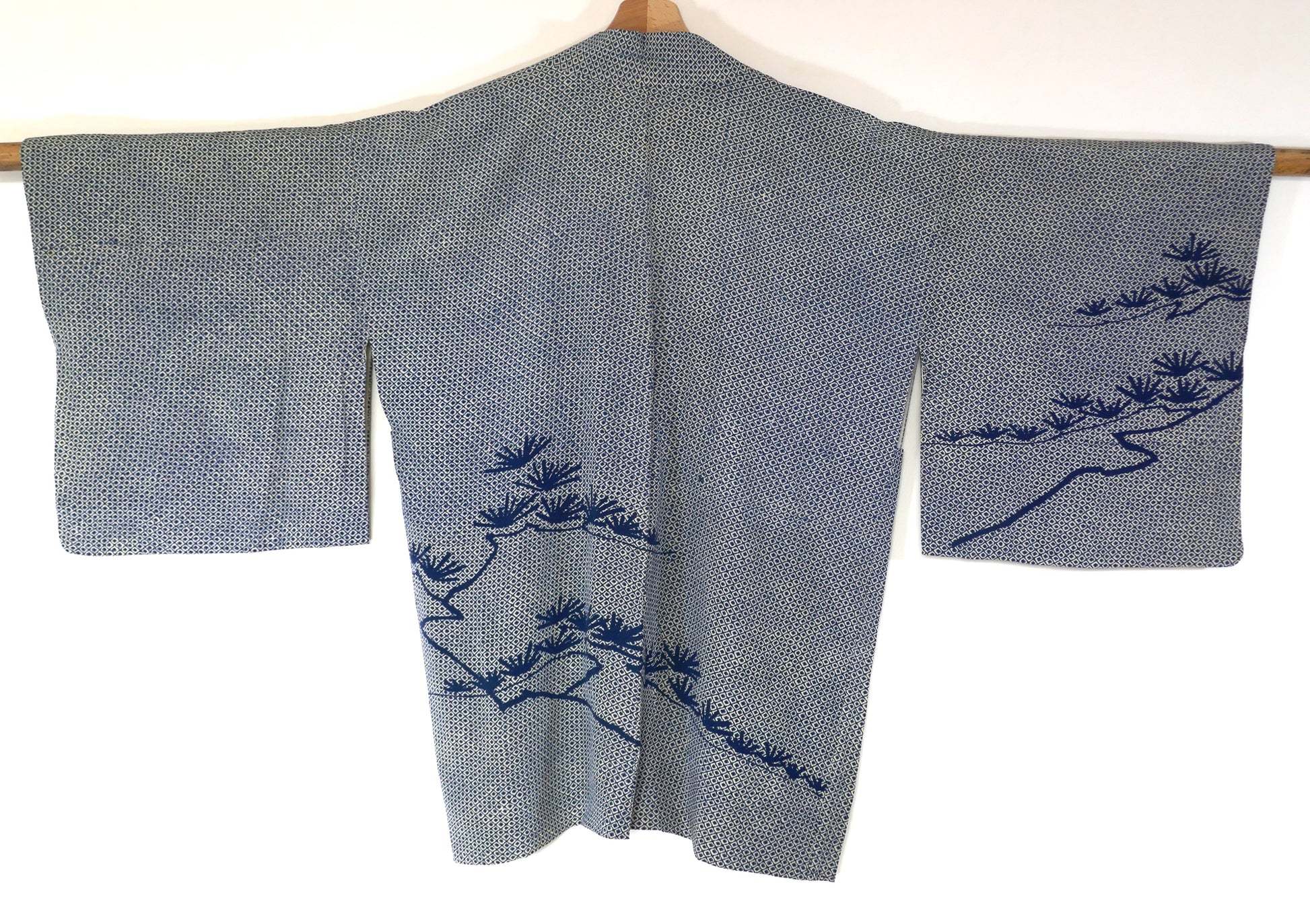 Dos d’un haori vintage en soie motif shibori, orné de motifs de matsu 松 teints dans un bleu plus foncé.