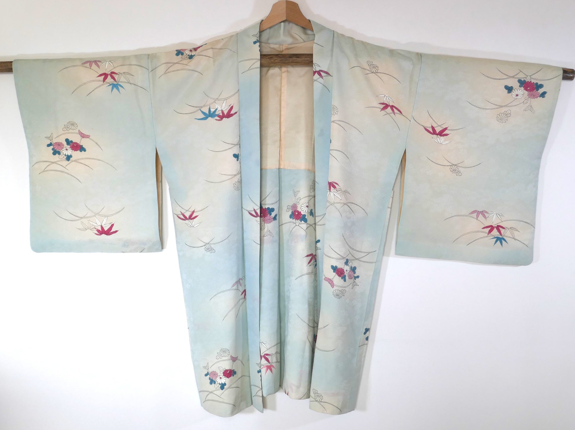 Haori vintage long en soie bleu pastel avec motifs de chrysanthèmes (kiku) et bambous (take), vu de face.
