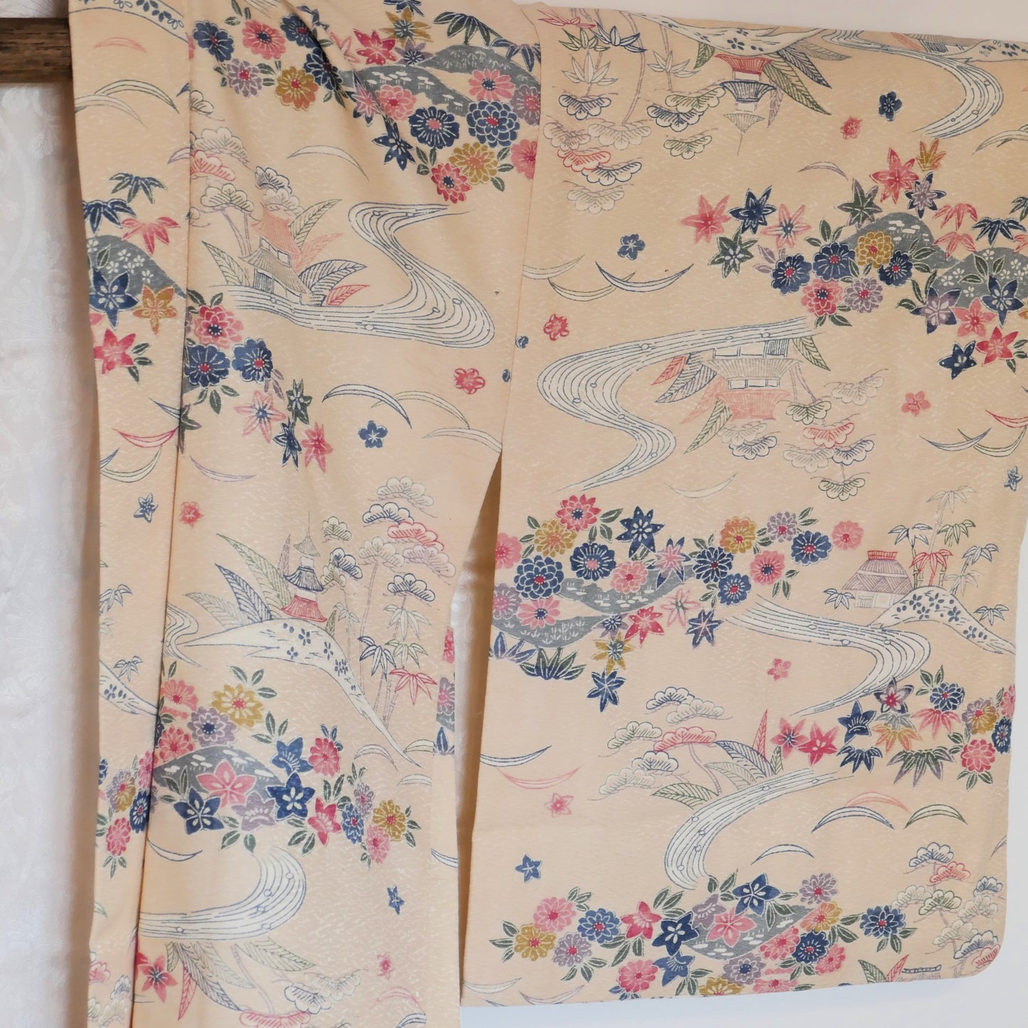 Vue rapprochée de la manche gauche du haori avec motifs de paysages japonais et feuillages.