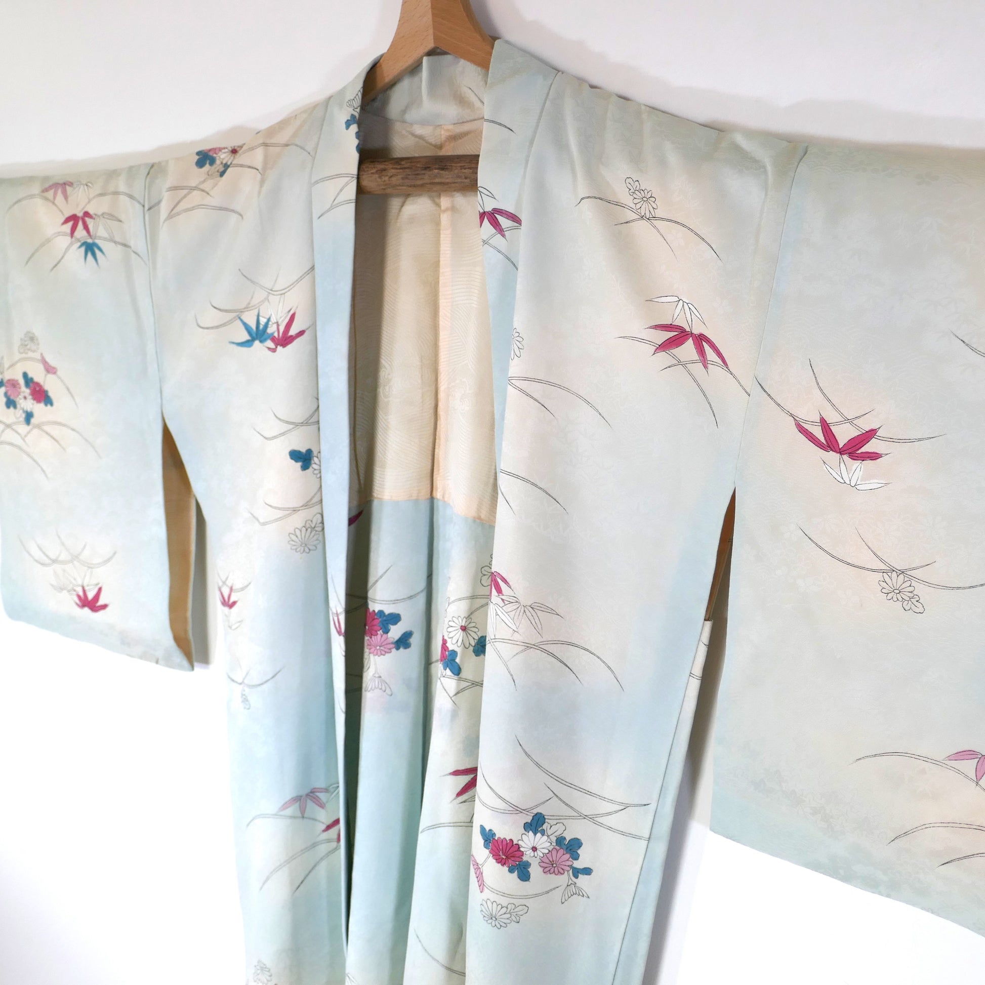 Haori vintage long en soie bleu pastel avec motifs de chrysanthèmes (kiku) et bambous (take), vu de trois quarts