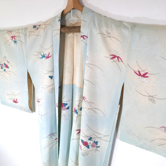 Haori vintage long en soie bleu pastel avec motifs de chrysanthèmes (kiku) et bambous (take), vu de trois quarts