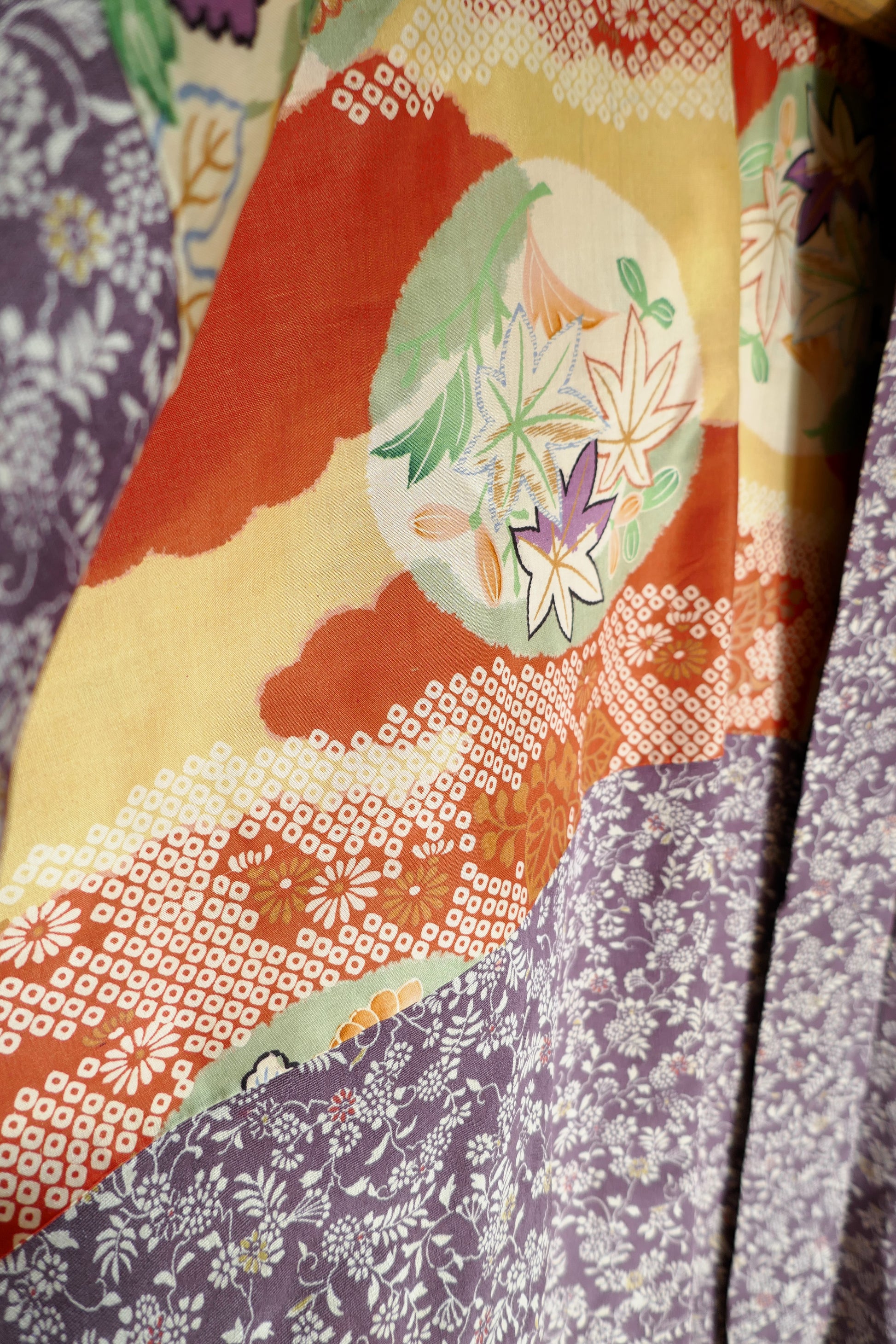 Vue intérieure du haori montrant la doublure colorée avec fleurs japonaises, momiji et nuages.