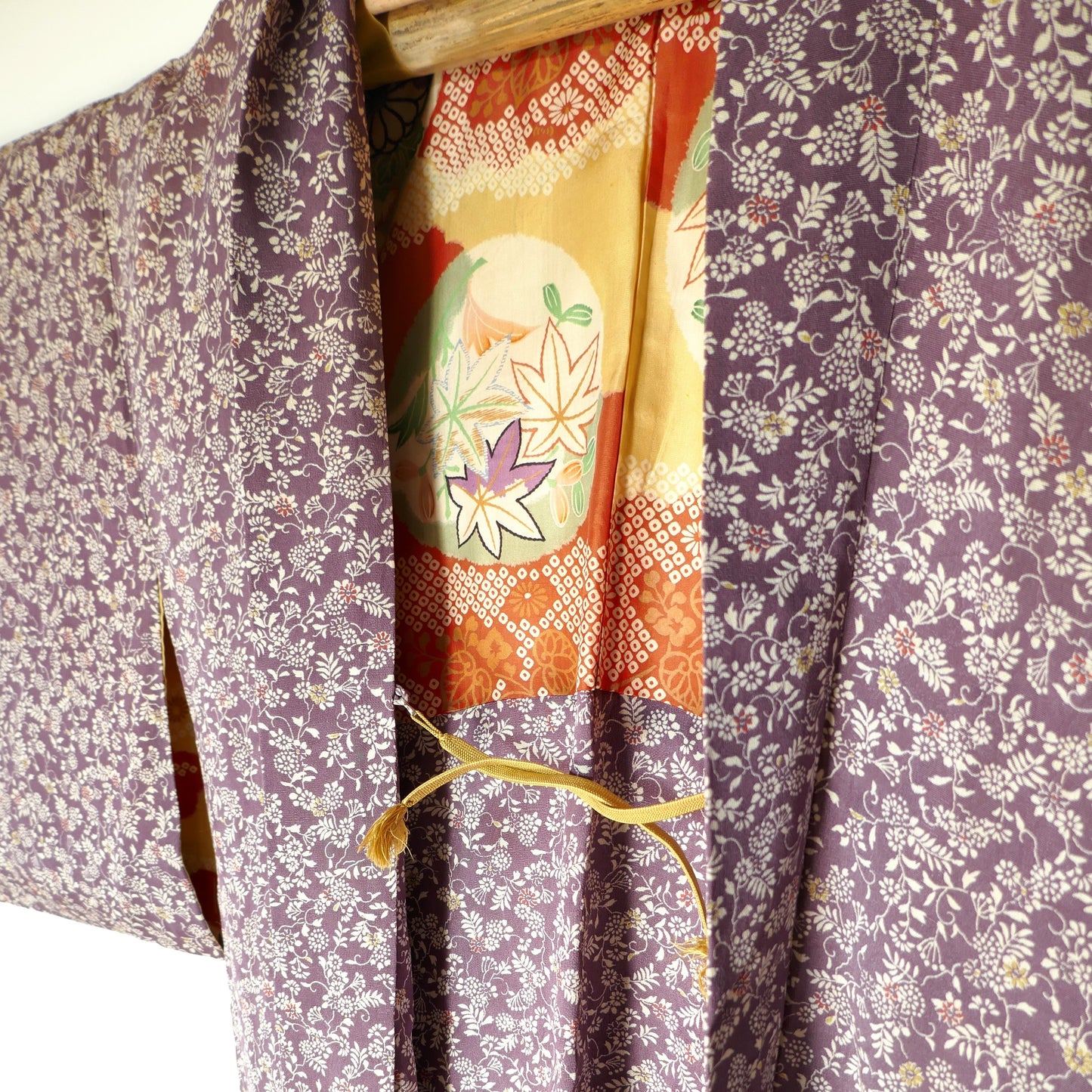 vue de trois quarts avec haori himo et motifs de la doublure du haori vintage japonais : feuilles de momiji, fleurs et graphismes colorés