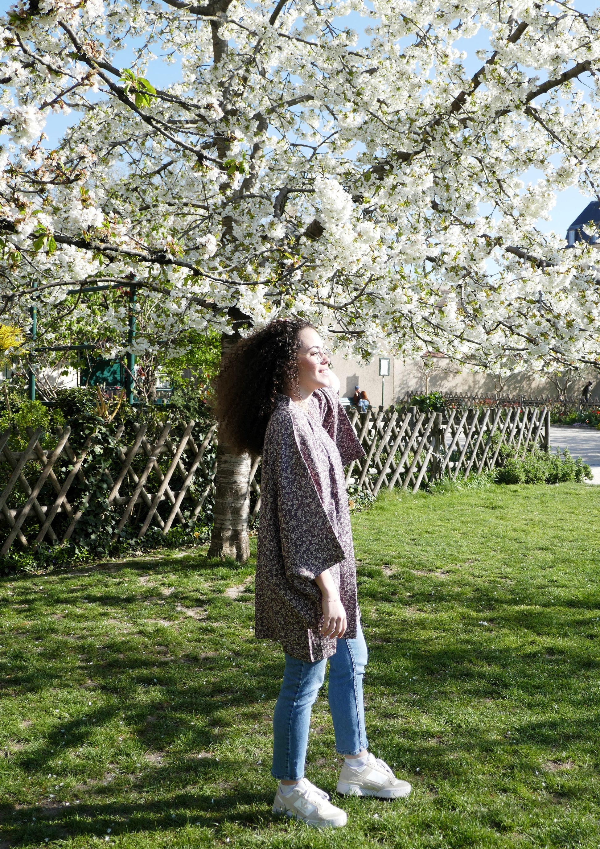 Haori violet prune en soie à motifs floraux porté de profil par Loony sous des cerisiers en fleurs