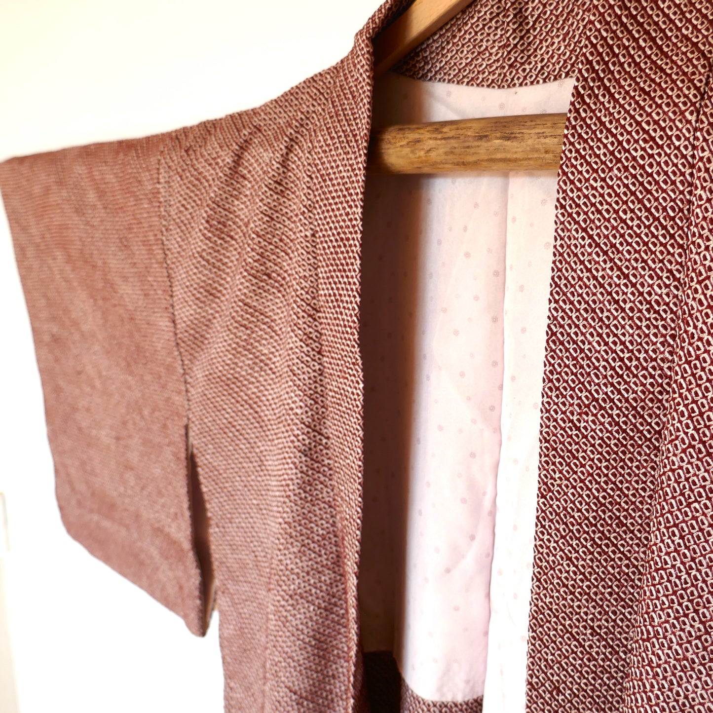 Zoom sur le col du haori shibori bordeaux en soie, doublure à motifs chrysanthèmes.