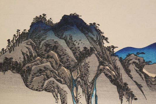 Gros plan du paysage montagneux de Fudesute dans la composition ukiyo-e de Hiroshige, avec superpositions de couleurs de la gravure sur bois.